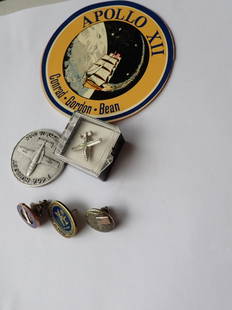 Apollo Space Program Awards: Pins, Tie Tack: Nasa Grumman 1st Manned Luna Module Landing Pin, Apollo Nasa Pin, Fairchild Republic Pin (no back), T46A Rollout Medal, T46A Tie Tack and Apollo X11 Sticker. From the Estate of Norman Silverman. The p