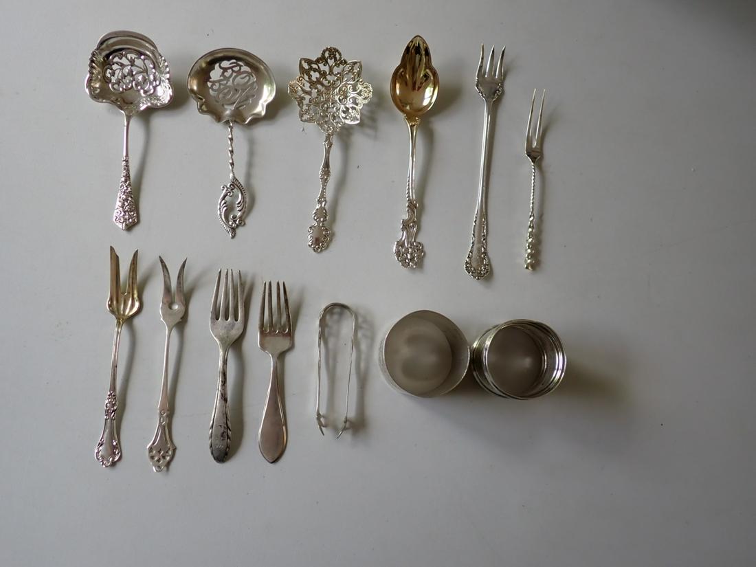 180/Sterling Bon Bon Spoons, Sugar Tongs, Forks, Napkin Rings: 3 Bon Bon Spoons (One says Bon Bon), 1 Sugar Tong, 6 Serving Forks, 2 Napkin Rings and 1 Gold Wash Serving Spoon. Appr. 6.9 troy Ounces - excludes knives. Please see photos for details and condition.