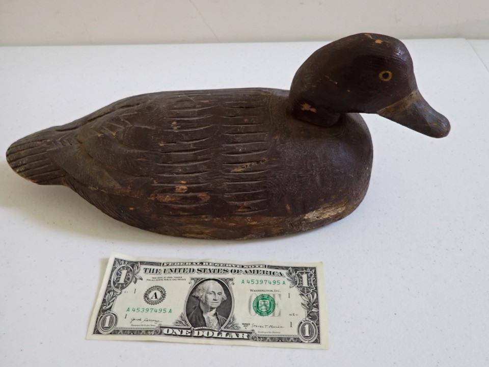 Vintage Wooden Duck Decoy. Red Paint. Grey Beak.: Yellow Painted Eyes. Carved Feather on tail. Rotating Head. 13". A little wear but overall good condition.