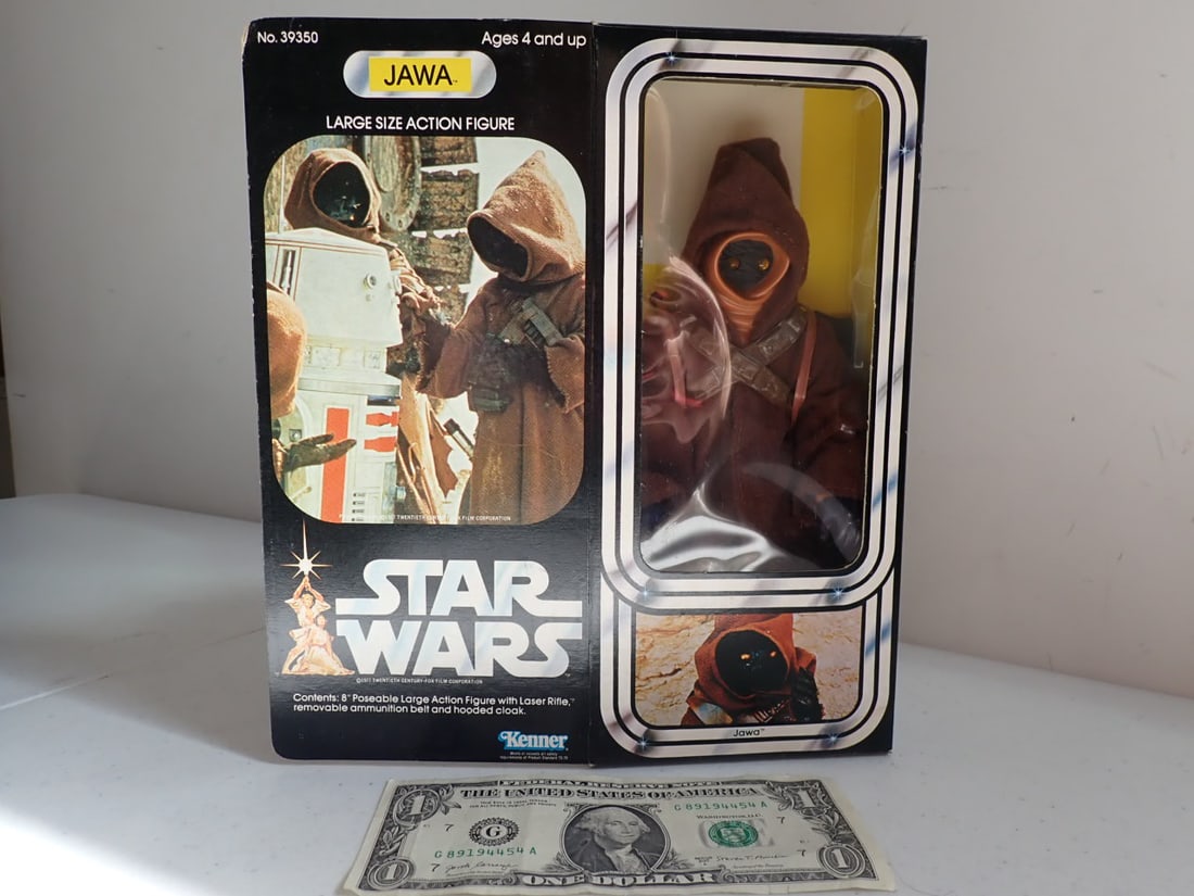1979 Star Wars Kenner Jawa 8" Figure in Box. No. 39350: c. 1977. Large Size Action Figure Contents: 8" Poseable Lare Action Figure With Laser Rifle, Removable Ammunition Belt and Hooded Cloak. Box opened but figure untouched. Box has wear.