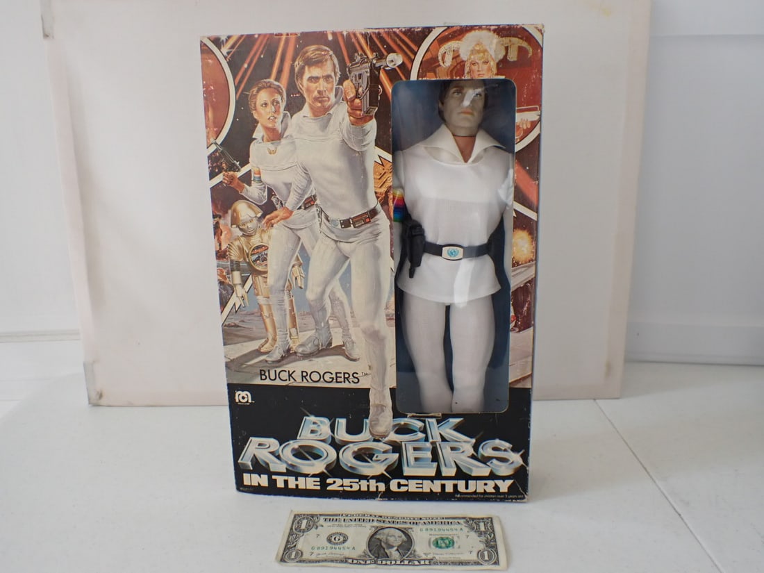 1979 Buck Rogers Doll in Box & Official Utility Belt in Boxes: Mego Corp Doll, Utility Belt by Remco includes Decoder Glasses, Wrist Watch, Ray Gun, Intruder Detection Badge, City Decoder Map and Secret Message. Intact in boxes. Has wear with creasing. Pieces ins