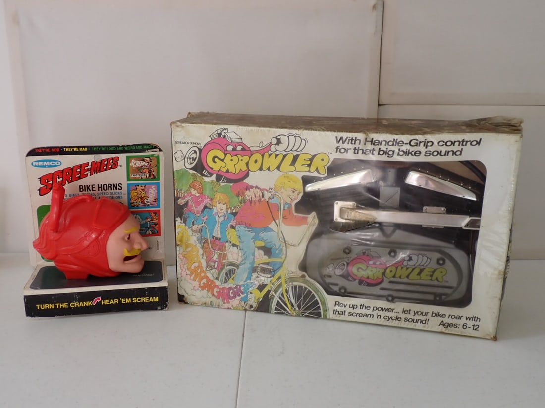 1972 Remco Scree Mees Bike Horn and Grrowler Bike Engine: Bicycle Engine Sound Maker. Red Baron Scree-Mees Bike Horn in Original Cardboard Pack. Back has some wear with discoloration and creasing. 1973 Scream 'N Demon's Growler Bike Attachment. Looks like mo