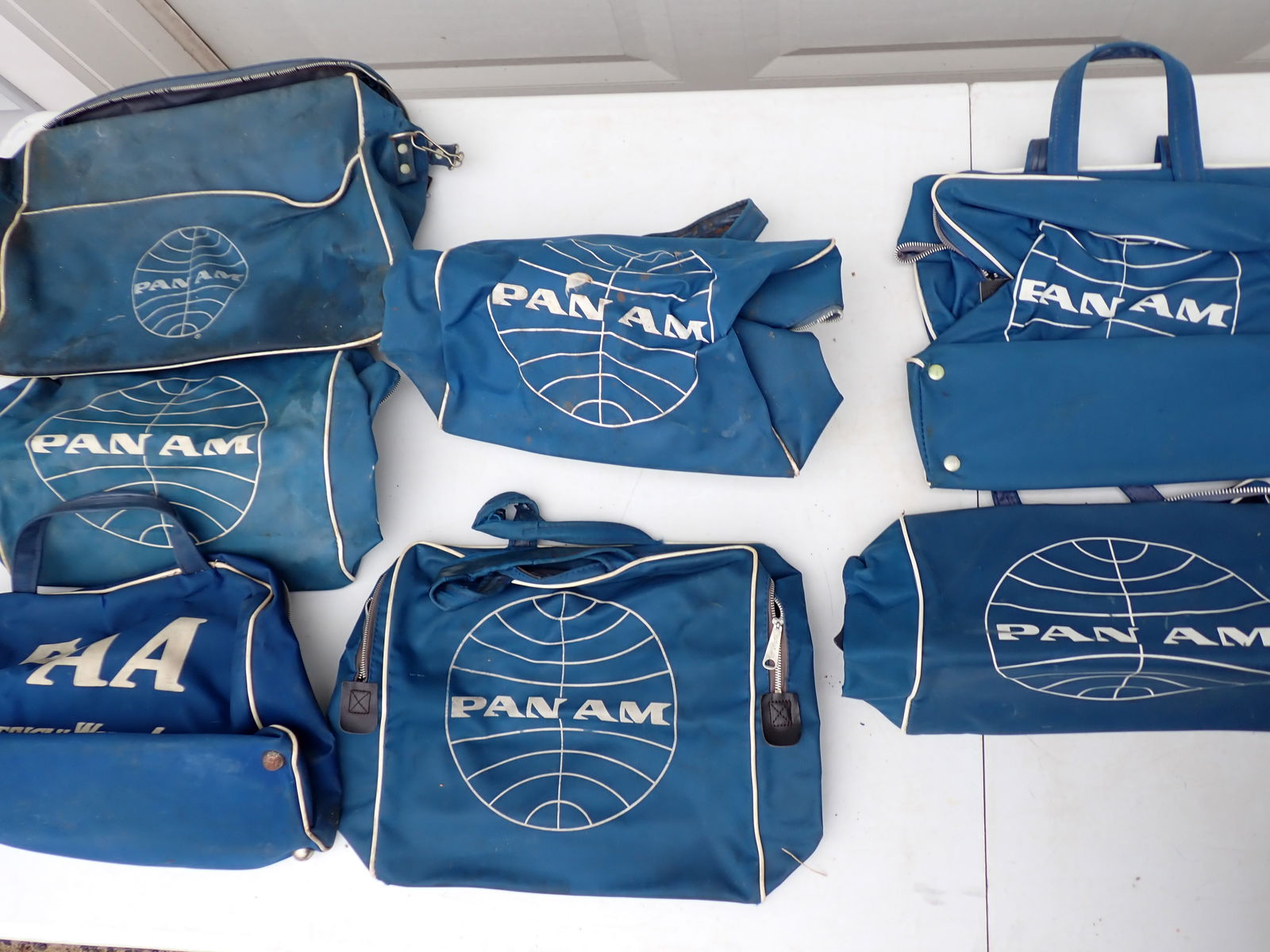 PAA and Pan Am Travel Bags: 7 Small Pan Am Travel Bags. One marked PAA "Pan American World Airways". One marked "747 time". Others ??? Pan Am. Two with light wear. Others have significant stains, soiling and wear.
