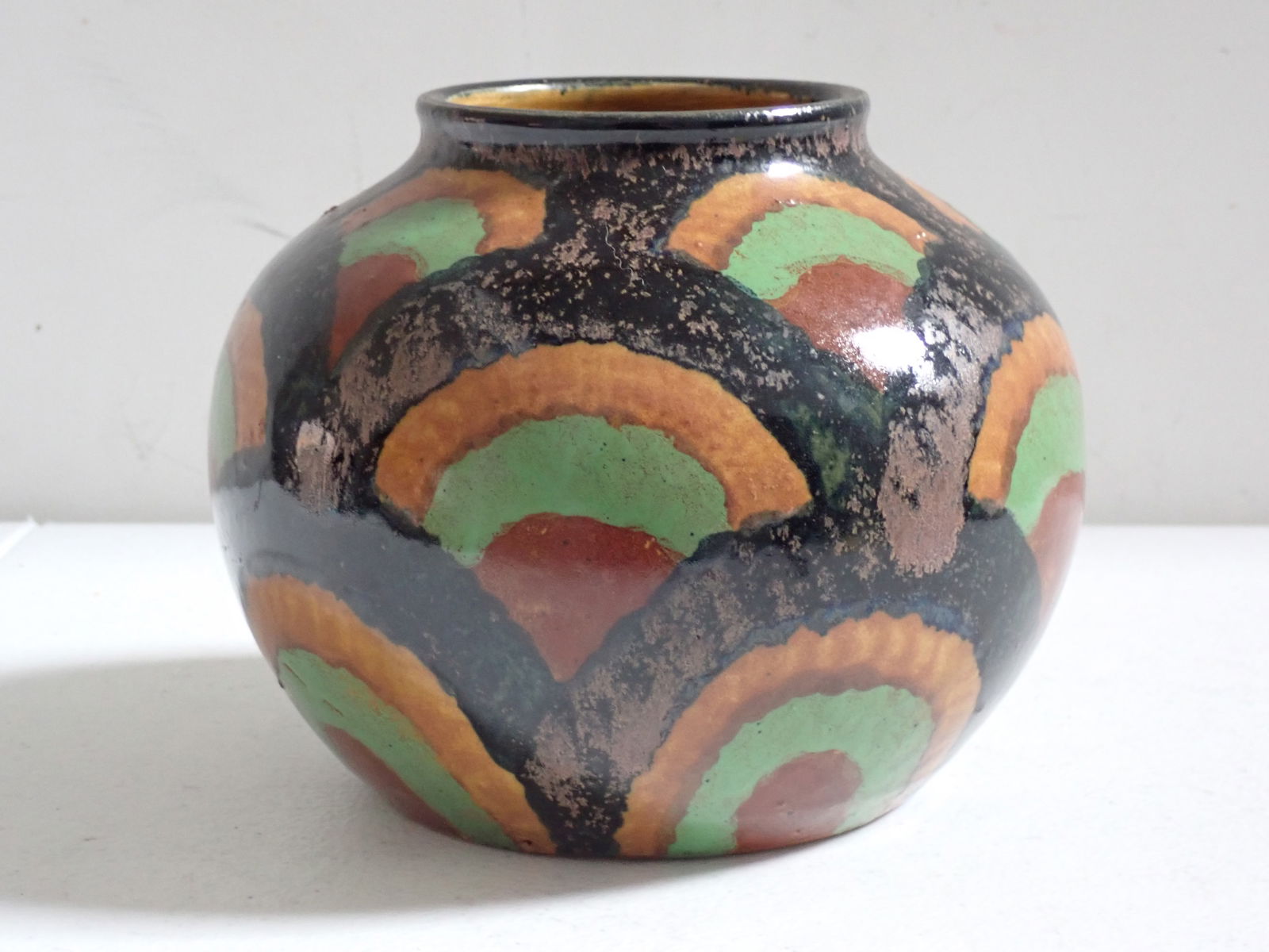 German Art Pottery Bowl.: Earthtone colors include green, clay and black. The Bottom is signed Germany with the numbers 84 & 11. 5" high x 6 1/2" in diameter.