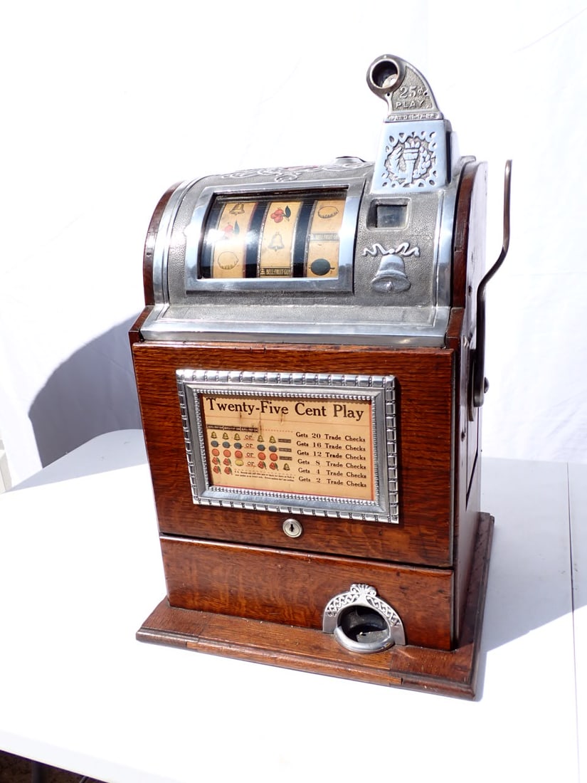 Antique O.D. Jennings Operators Bell 25 Cent Slot Machine: Early 20th Century. Cast Aluminum Top with Oak Panels: Original 25-Cent Three Real Slot Machine with Payout Chart. 24 1/2" High x 15 1/2" wide at base, 14" deep. Has some splitting on back panel but i