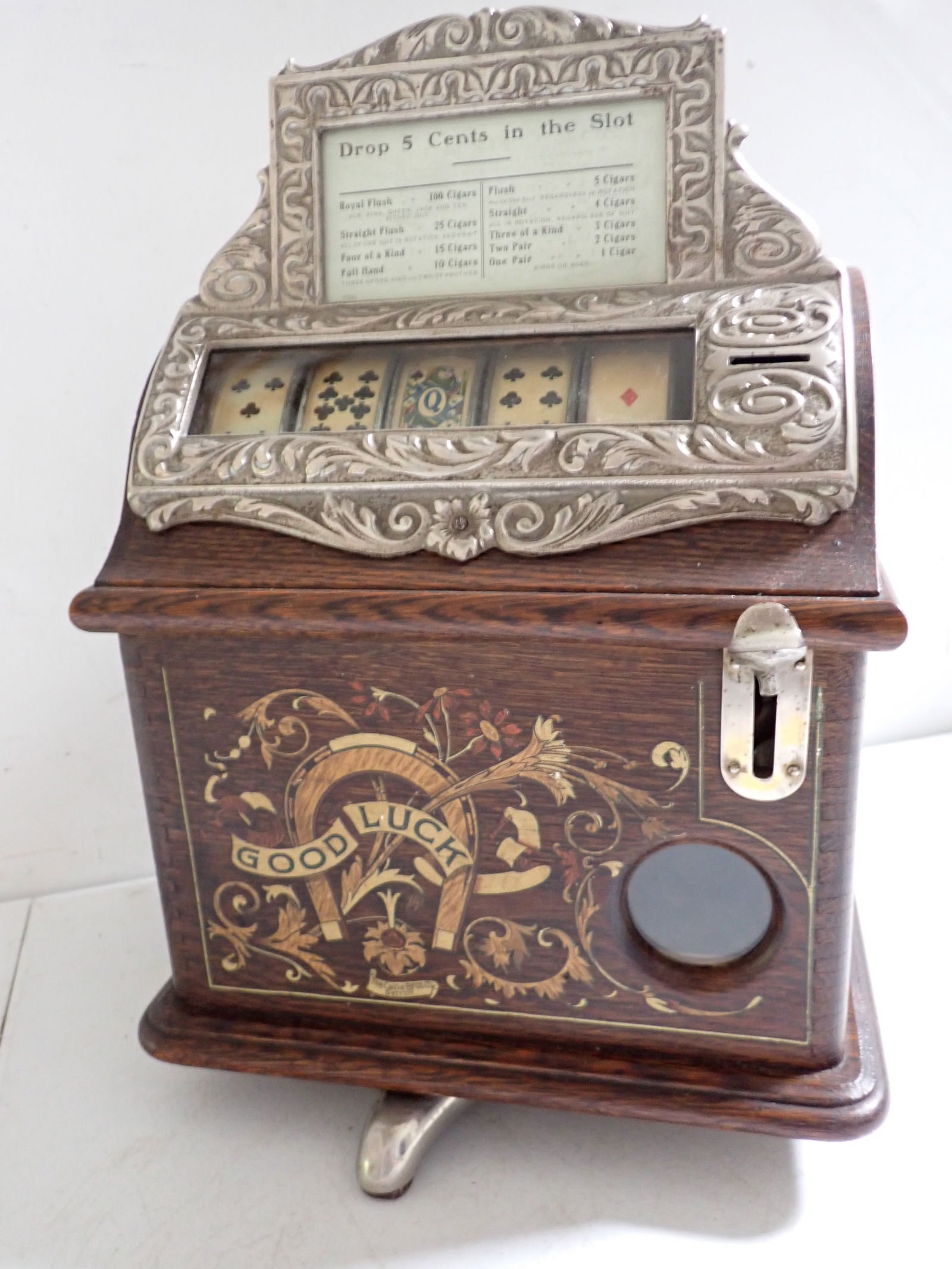 Caille Bros. 1 Cent "Good Luck" Poker Reels Early 1900s Trade Stimulator: Nickel Plated Rules Card and Glass Window Frame. Good Luck with Horseshoe on Oak Case. Card says "Drop 5 Cents in the slot." Royal Flush 100 Cigars, etc." It is on a 4 leg rotating stand. Ornate " Cai