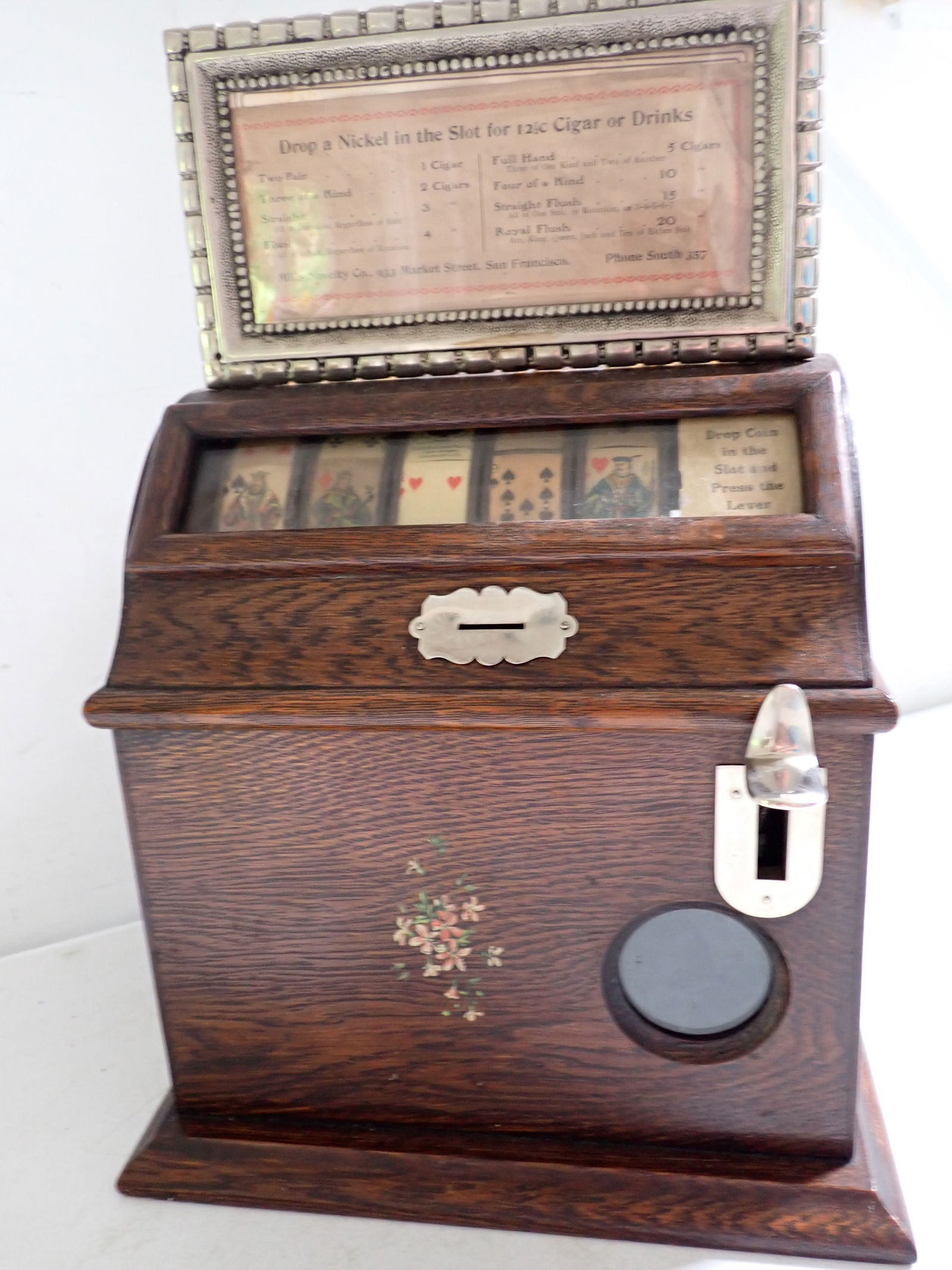 Mills 5¢ 5 Reel Trade Stimulator - Nickel Wins 12 1/2¢ Cigar or Drinks: Floral Design on 3 Sides with Mills Novelty Labels on the Side. 16 1/2" High x 11" Wide x 9 1/4" Diameter. Back of Case has missing piece. Works but some reels don't spin as much as others.