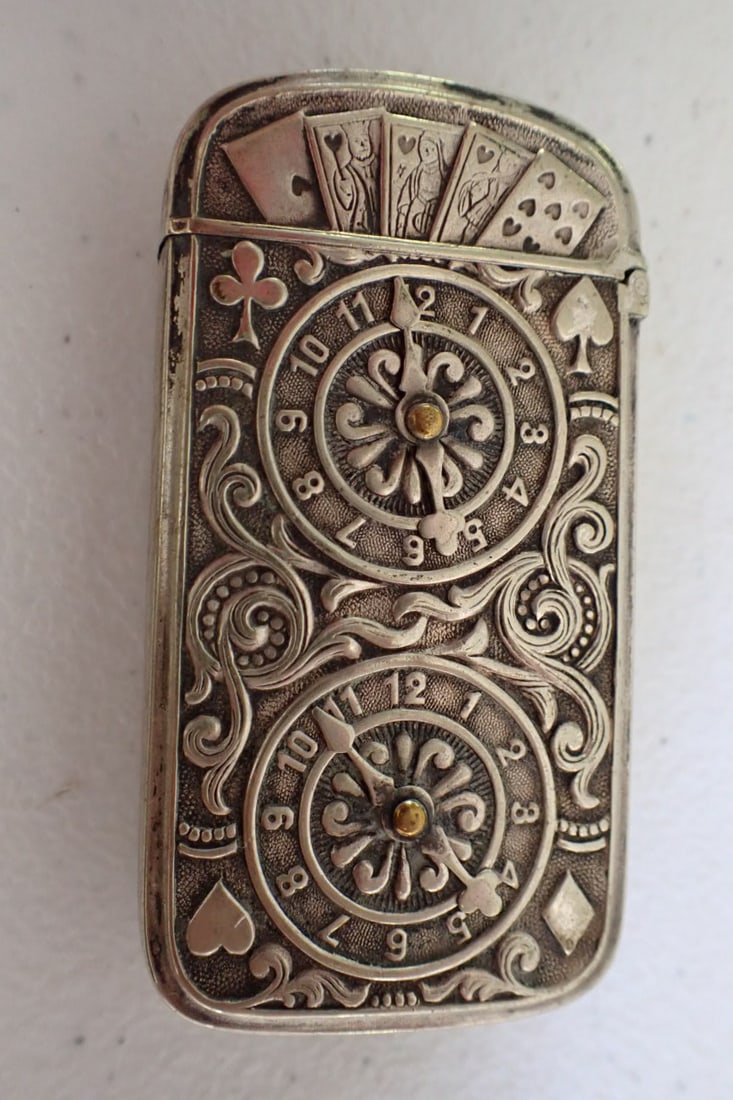 Hand of Cards and Roulette Wheels Matchsafe: Hand and Sleeve with 5 playing cards on one side, opposite side has gaming wheels with movable hands. Has all 4 playing card suits and 5 cards at top.