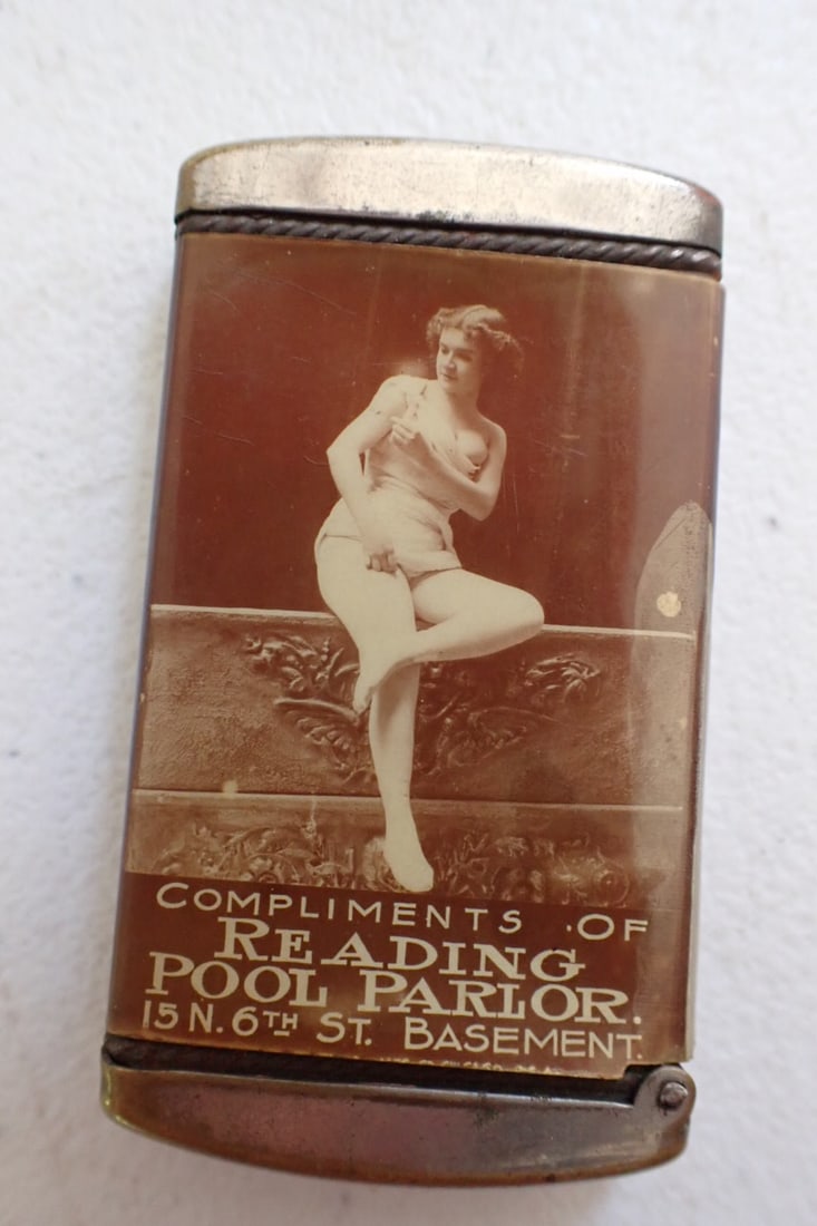 Turn of the Century Risqué Reading Pool Parlor- Celluloid Matchsafe: Match safe has Risqué woman on one side with writing Compliments of Reading Pool Parlor 15N. 6th St. Basement. Reverse side show woman laying on sofa. Celluloid a little loose but overall good condit