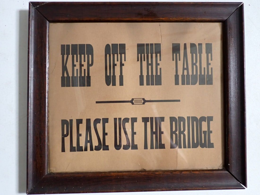 Pool Hall Sign "Keep Off the Table Please Use the Bridge" in Wood frame: Sign states: "Keep off the Table Please Use the Bridge" Frame:14 1/2" x 16 1/2" Sign: 11 1/2" x 14". Has some tears on top and bottom. Frame is loose.