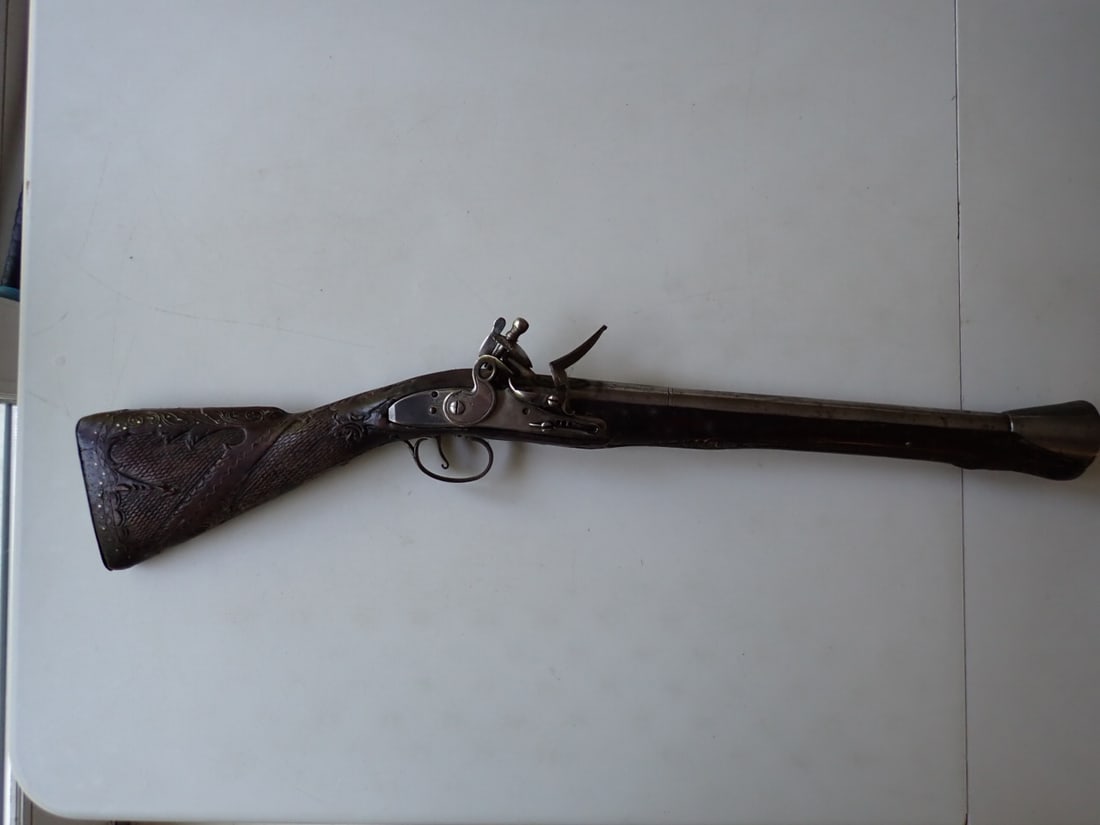 Ornate Carved Blunderbuss with Engraved Metal Work: Ornately Carved Blunderbuss. Engraved barrel and trigger. Trigger mechanism works. Has chip under stock. Metal has some wear and oxidation. 24". Barrel 14".