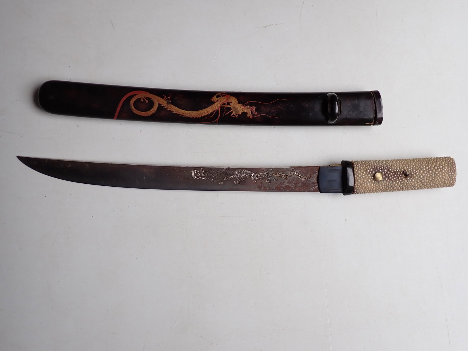 Tanto with Dragon Design Blade and Sheath: Dragon Design Blade and Dragon Deign Lacquer Bamboo Sheath. 16 1/2". Blade 12". Blade has rust. Handle missing pin and handle grip cover is split.
