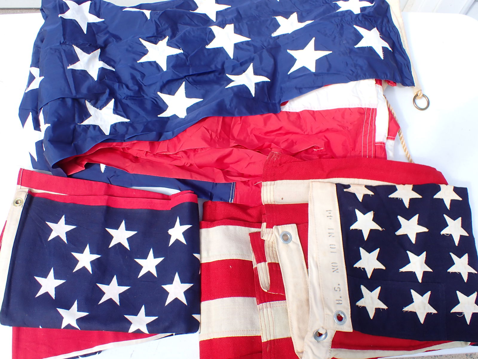 3 US Navy 48 Star Flags: US Ensign 100% nylon 48 Star Ships Flag. Approx. 119" x 58" . Good Condition. A 48 Star U.S. No 10 M. 44 Cloth Flag. 66" x 31". Good Condition. A 48 Star Cloth Unmarked. 57" x 36" Flag. Has some stain