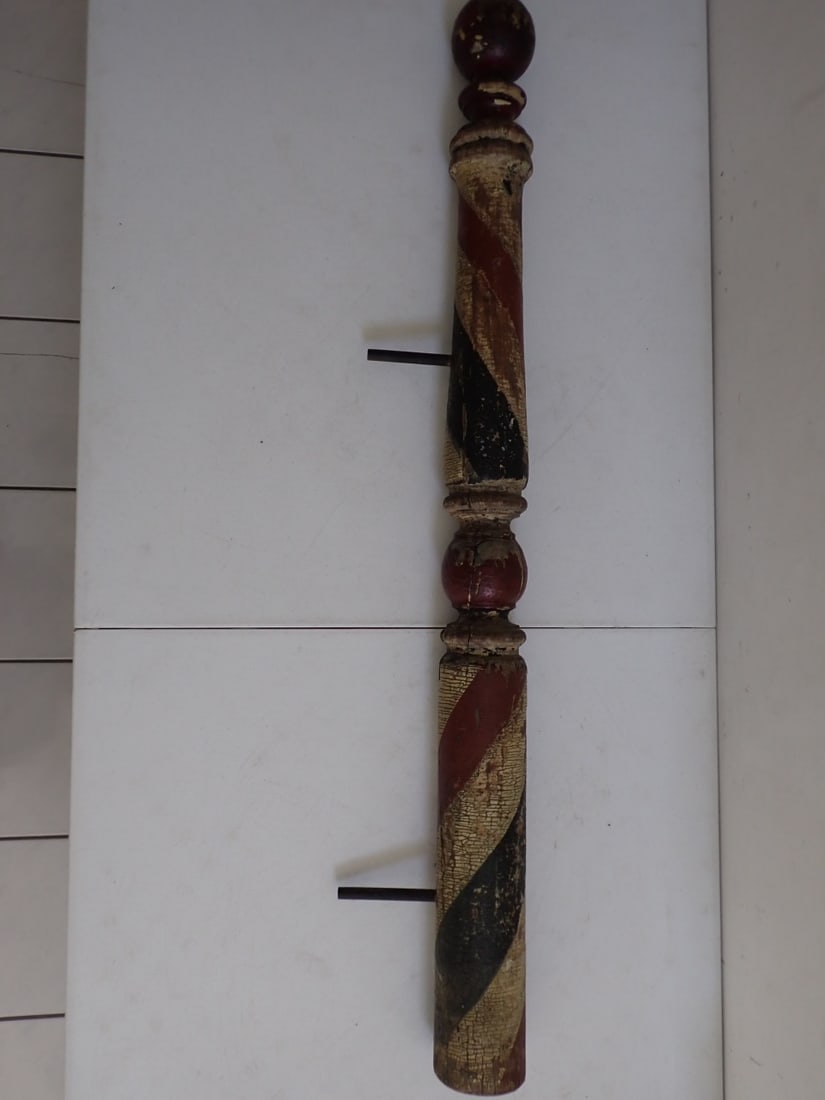 Wooden Folkart Barber Pole: 47". Natural wear with some paint cracking and some paint loss. Has two dowels inserted where it hung on the wall.