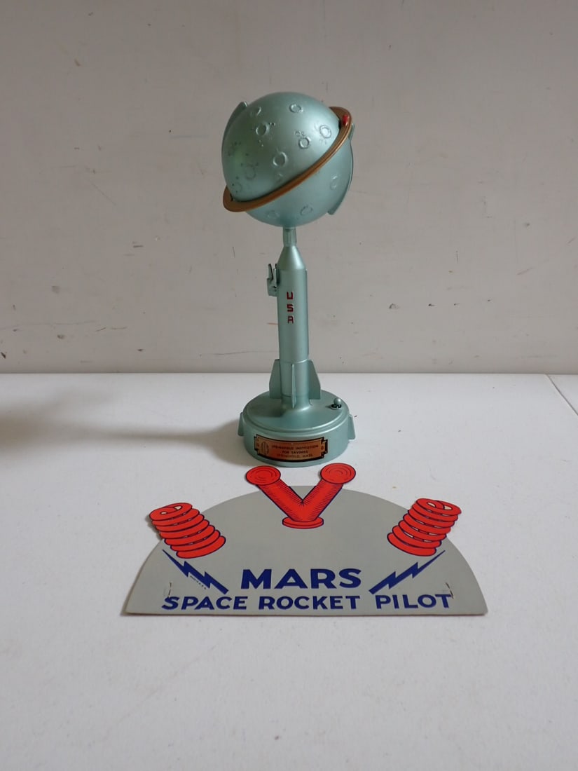 Model 1000 Destination Moon Bank & Cardboard Mars Space Pilot Hat: Bank marked Model 1000 Destination Moon Bank also marked Note:Keep Spring Greased -Pattern info on base. Label shows it was made for Springfield Institution for Savings, Springfield, Mass. 10 1/2" hig