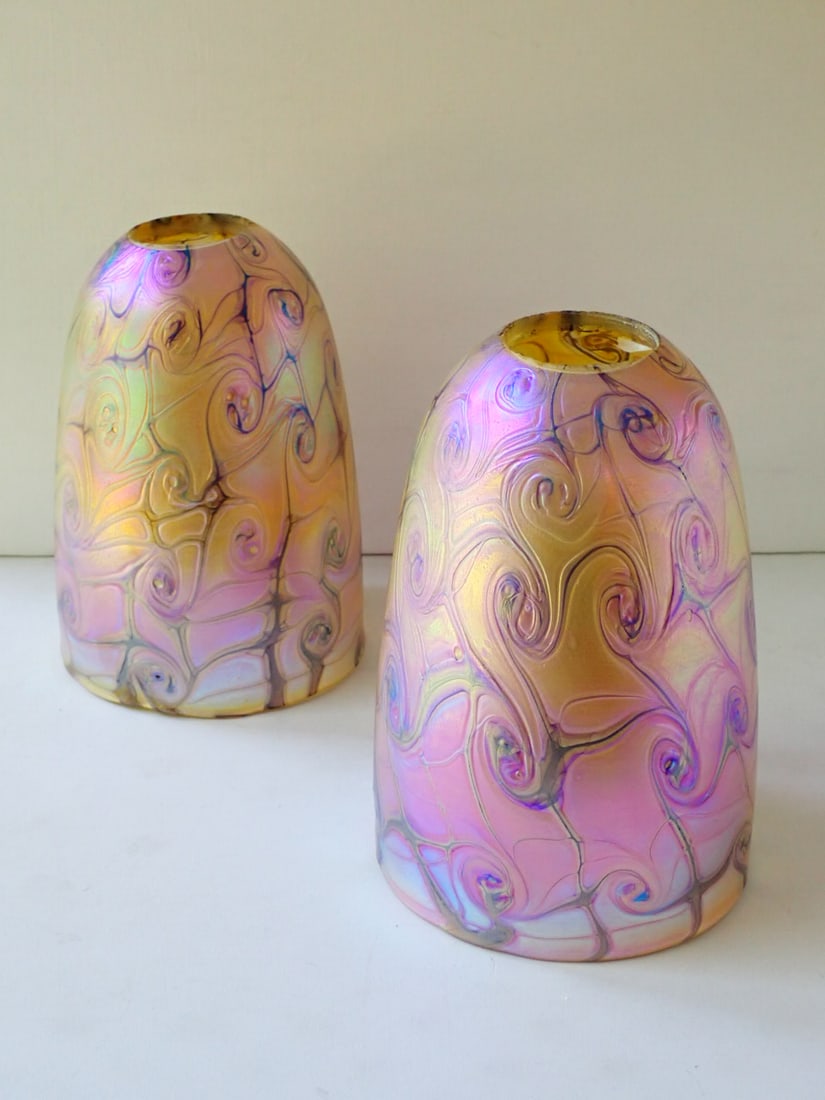 Pair of American Art Glass Shades: gold glass with iridescent swirl design cased on clear glass. Unsigned. Attributed to Quezel. 5 7/8" diameter x 8 1/8" high. Manufacturing chips at circular fitter hole. No cracks or chips.