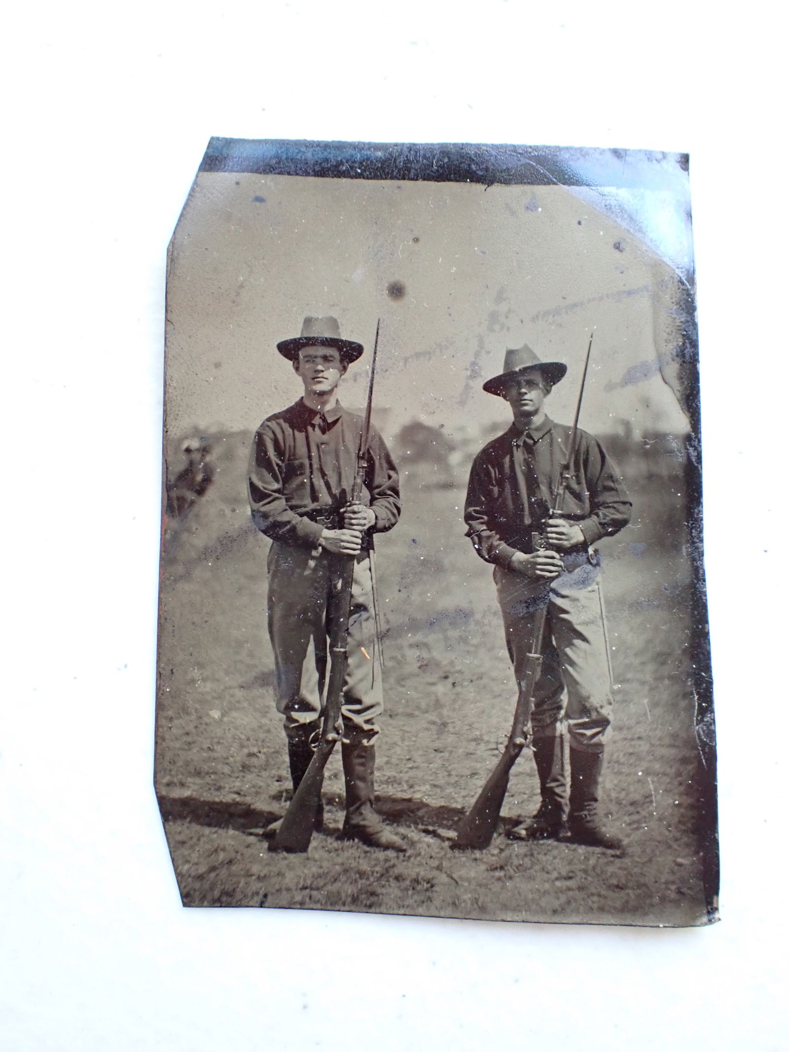 Tintype of Soldiers with Rifles and Bayonet: Picture of 2 Soldiers in Uniform with Rifles and Bayonets. 3 1/2" x 2 1/2". Uneven border.