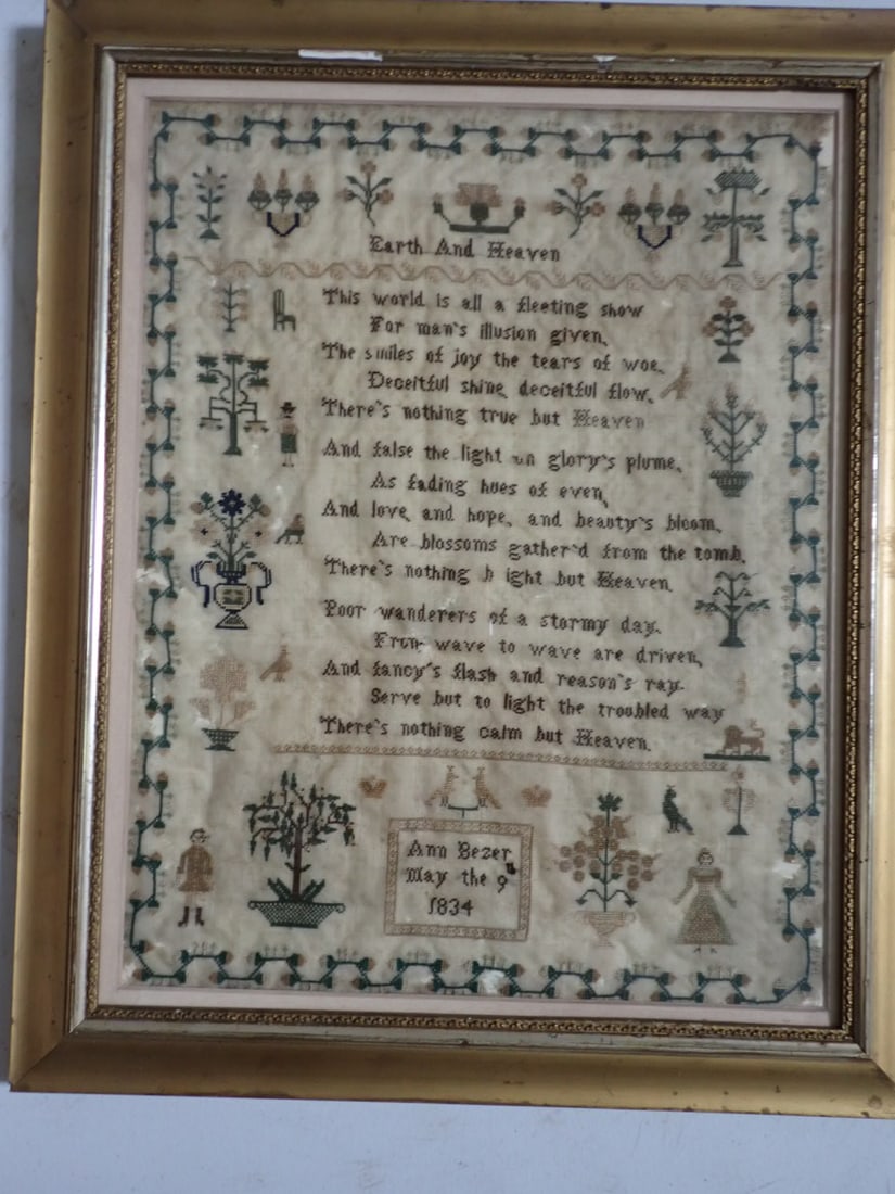 1834 Sampler by Ann Bezer: Earth and Heaven Poem with Floral Designs, Birds and People. Frame 19 1/2" x 16". Sampler 17" x 13 1/2". Cloth is worn and has several holes. Frame has light wear. Stain on back of frame.
