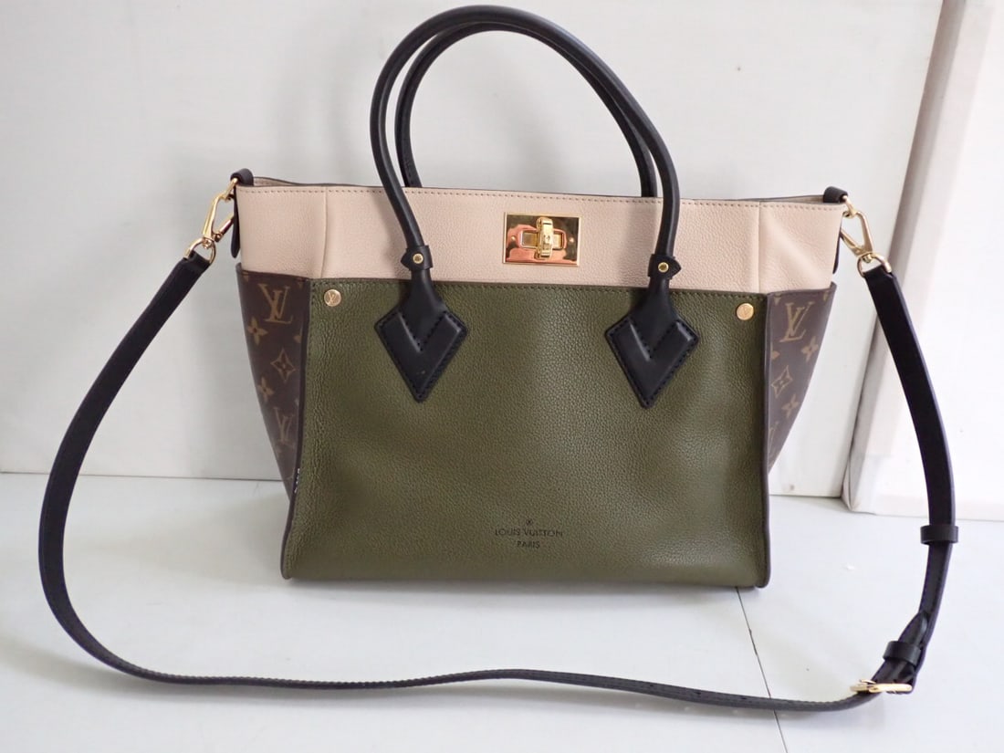 LOUIS VUITTON Laurel Leather Canvas On My Side Handbag: Bi-Color pebbled leather exterior, suede interior.Over good condition slight mark on piping (see photo) otherwise in unused condition. 12" Wide 10" high with leather shoulder strap