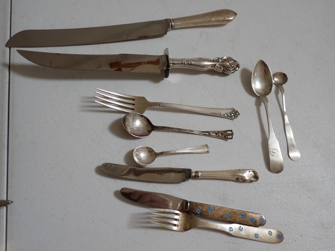 Sterling and Coin Silver flatware and Service pieces: (1) A Nichelsen Copenhagen fork and knive with blue floral design. (2) Carving Knifes, (1) lunch knife with dented handle. (1) salt spoon 3 1/2". (1) Unmarked reticulated Silver Spoon 5 1/4". (1) 7" R