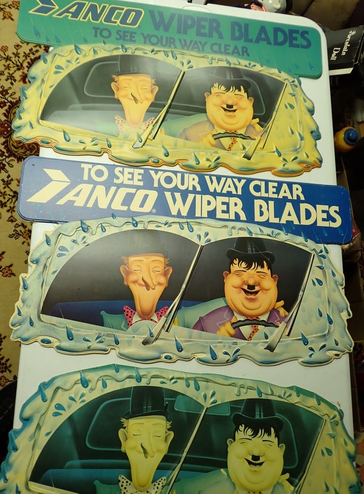 3 Anco Plastic Wiper Blades Advertising Signs: Laurel and Hardy Embossed Plastic. Green Top and Blue Top Signs measure 18" x 32". The Blue top sign has some light cracking and soiling and fading. The other one measures 13" x 30". Marked Anco Wiper