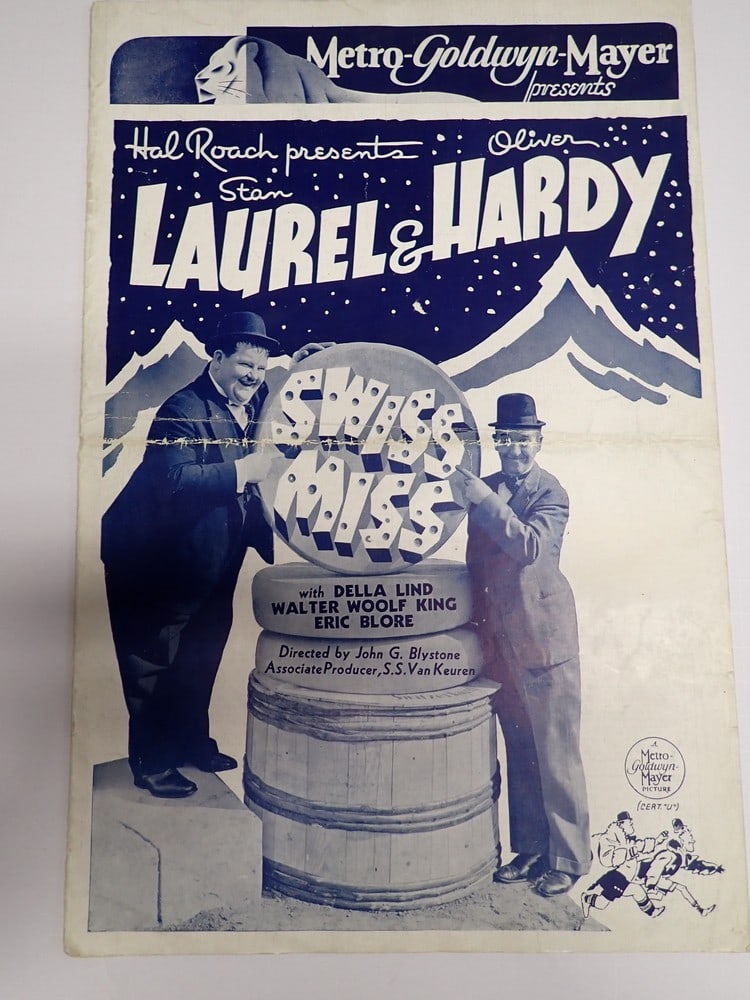 1938 Laurel and Hardy Movie Press Sheet/Brochure: "Swiss Miss". Front gives synopsis of the movies. The reverse lists prices for posters and lobby stills. 15" x 10". Has crease where folded in center. Has some writing on front page and other wear.