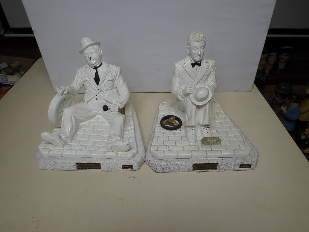 Laurel and Hardy Septimo Arte Composition Figures: Paper Label marked Urregui. Depicts Laurel and Hardy seated with broken can paints. Hardy 9 1/2". Laurel 10". Marked Urrer.