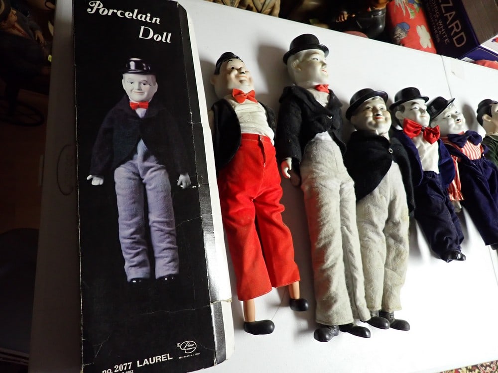 14 Laurel and Hardy Porcelain and China Dolls: Porcelain Laurel in Box. Dolls range in sizes 8 1/2" - 22 1/2". Most show some wear.