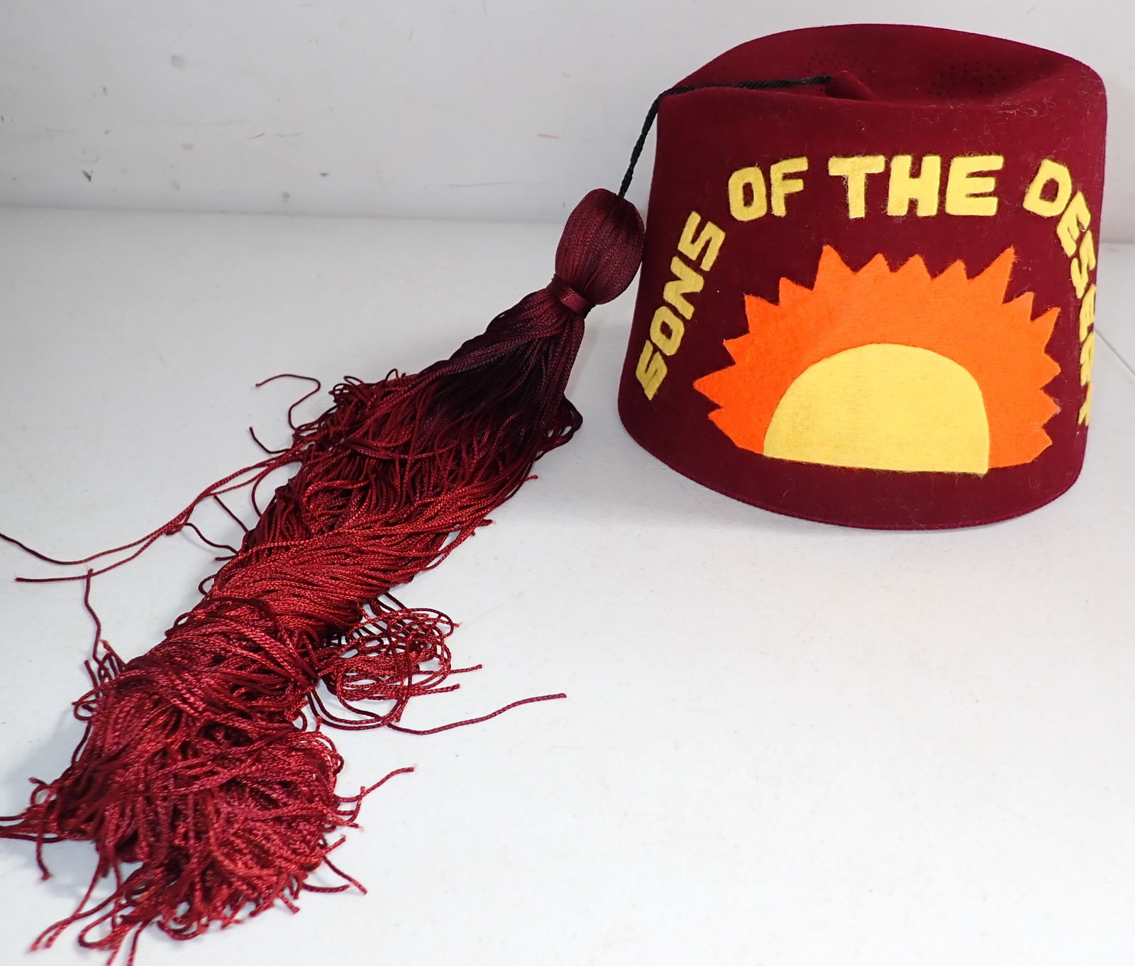 Sons of the Desert Fez: Well made velvet fez with air holes on top, tassel, leather inside around rim. Labeled size 7 ¼. Has cloth (felt) Sons of the Desert lettering and design. 6” high.