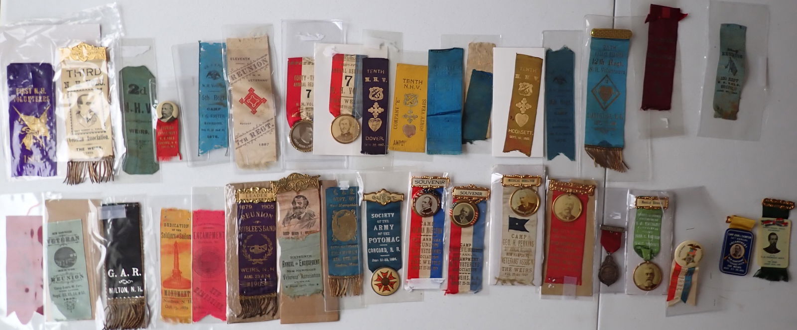 New Hampshire Civil War Regt Ribbons, GAR Pins: New Hampshire Civil War Regiment Ribbons, GAR Pins, etc. 1900 NH Veterans Association celluloid card with ribbon. 1910 34th New Hampshire Veterans' Encampment metal piece with mirror back on ribbon. O