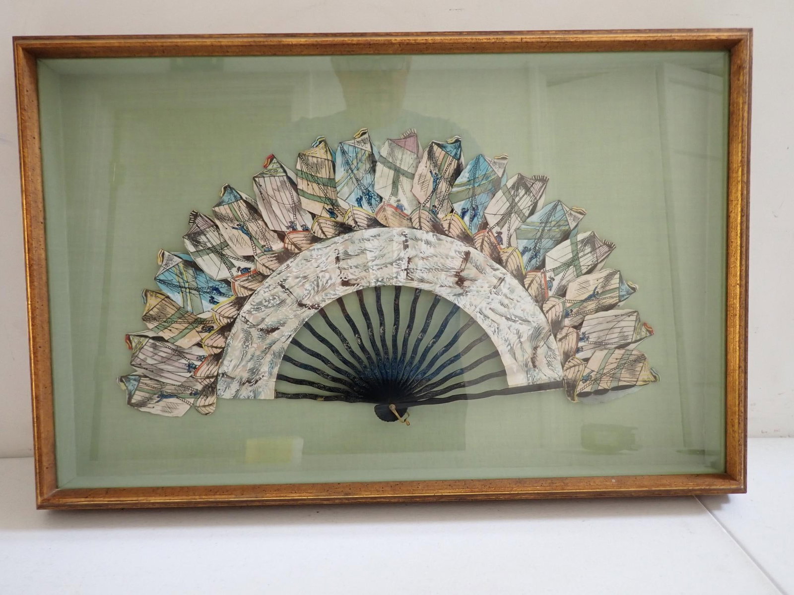 Turn of the Century Fan with Diecut Ships: Fan in shadow box has 18 diecut ships. Gold leaf design on handle. Fan appr. 9" x 17 1/2". Frame: 15" x 23 1/2".