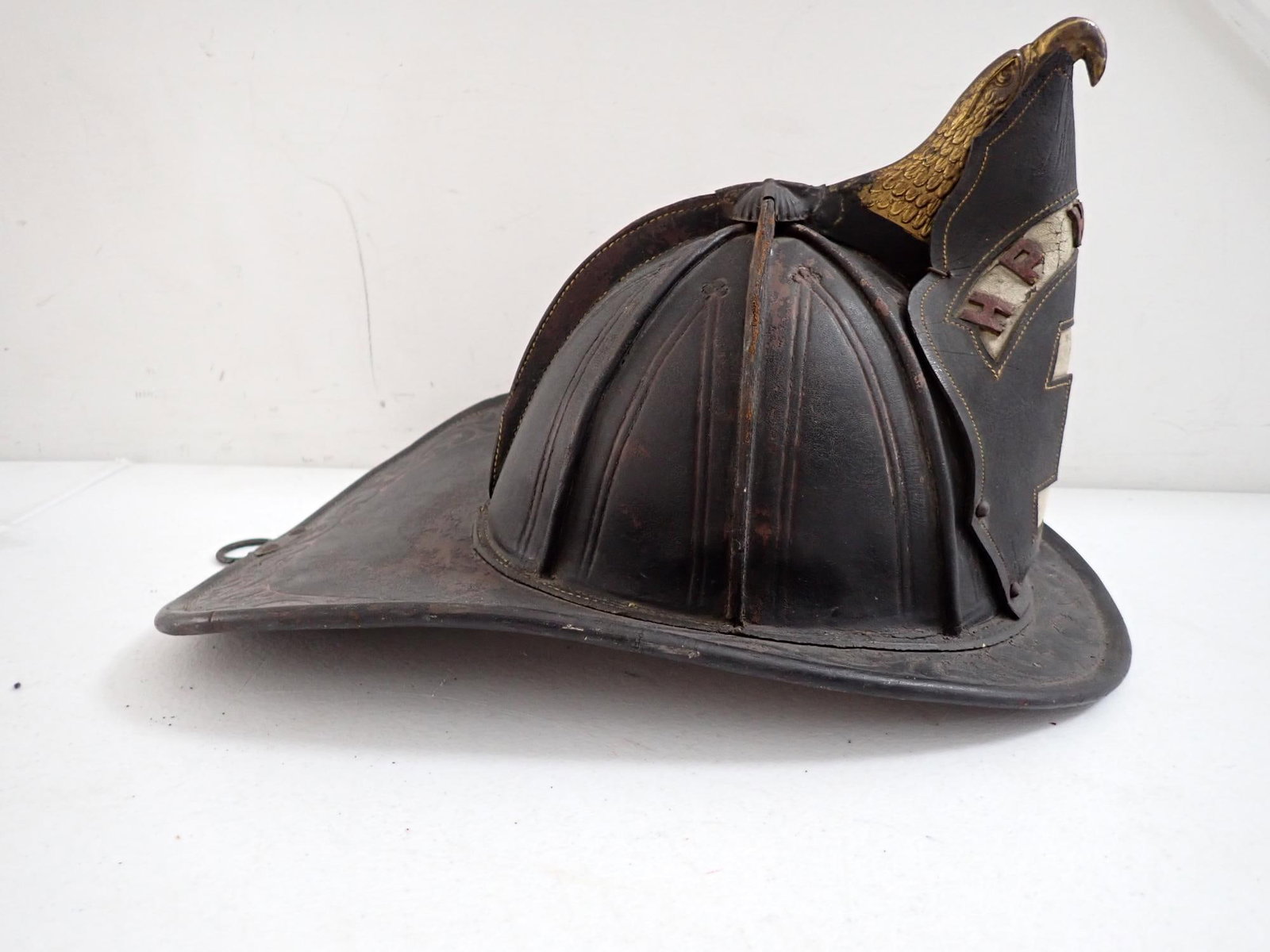 High Eagle Leather Fire Helmet: Marked HP Hose Co. Tooled Leather with brass eagle. Shows some wear but overall good condition.