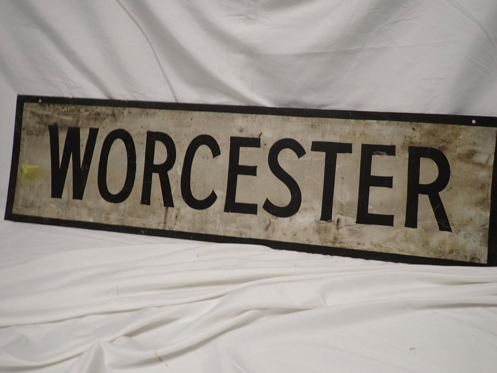 Worcester Metal Railroad Sign: Sheet Metal Worcester Sign. Has grease and staining from normal wear. A yellow arrow has been painted on left side. 10 1/4" x 36".