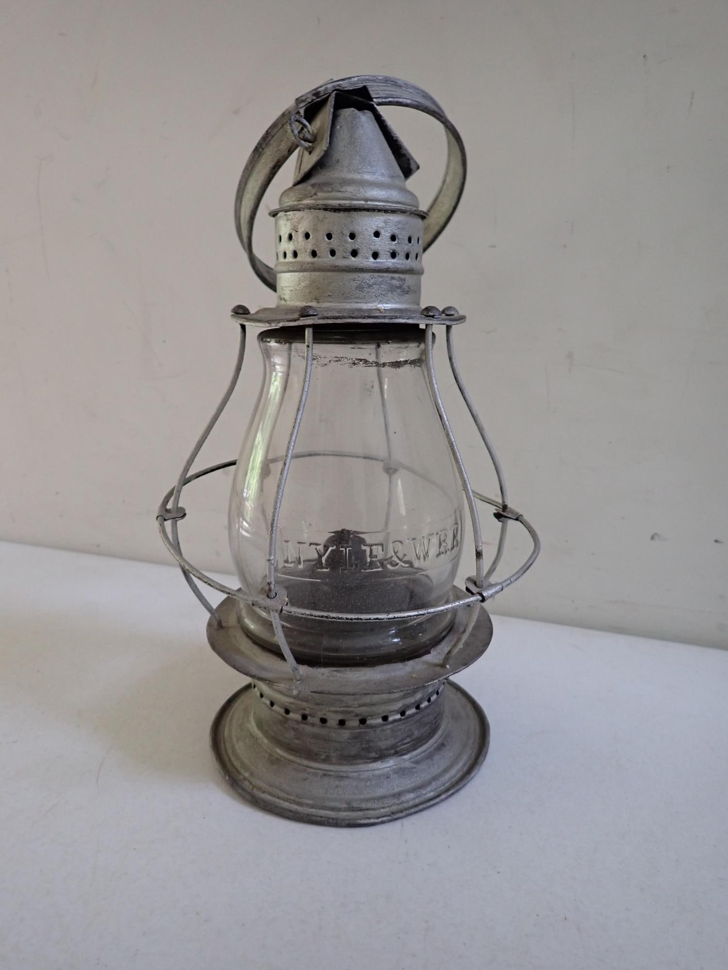 New York, Lake Erie, and Western Railroad Lantern: Operated from 1878 to 1895. Embossed globe. Lantern has been painted silver. Cage has some bending. 18" from base to top of handle.
