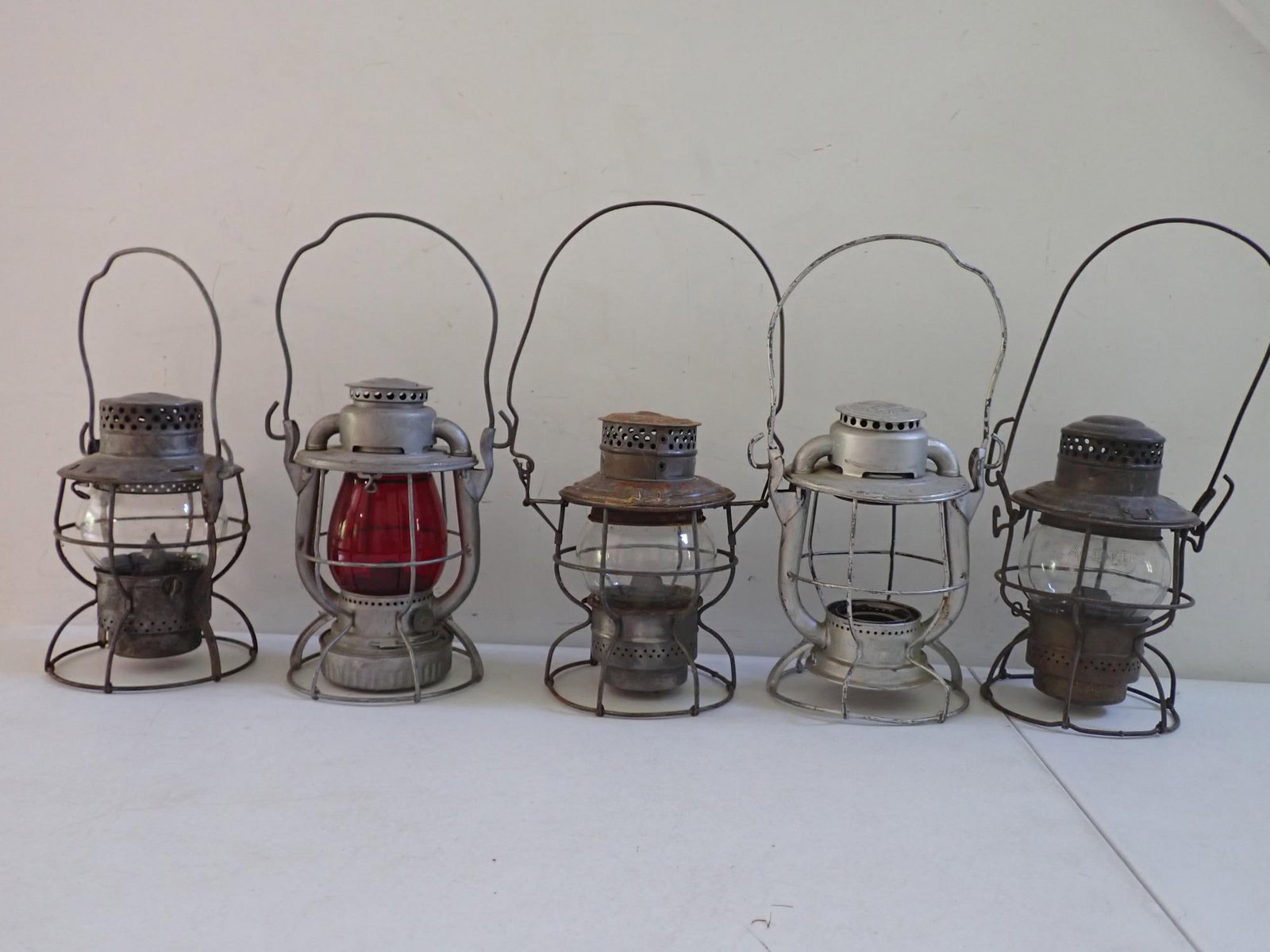 NY, O, & W Railroad and other lanterns: JCL (Jersey Central Lines) with red globe. New York, Ontario and Western Railway dented, painted silver, and no globe. NYCS (New York Central System) with some wear and light surface rust. CPR