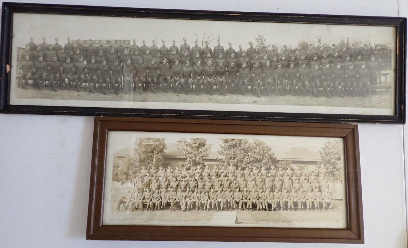 WWI and WWII panoramic soldier photos (2): WWI photo Company A 11th @ Camp Meade, Md. Nov, 18, 1919. Photos signed Weintraub. Frame 33" wide x 9". Frame has some chipping, photo slight discoloration --WWII soldiers photo. Frame 22" wide x 9