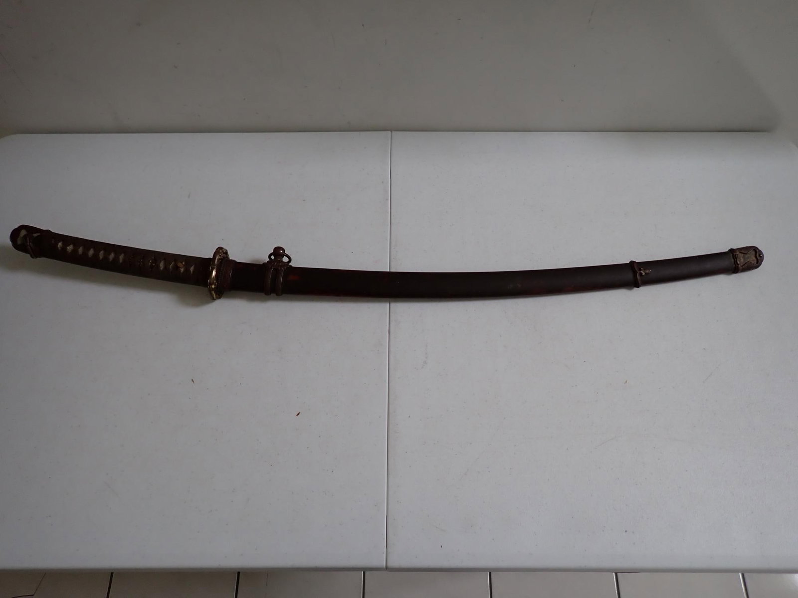 Samurai sword bronze fittings signed by maker: Approximately 37' length. Blade 26." Blade was oiled at some point. Some red paint on scabbard. Tip is chipped off.