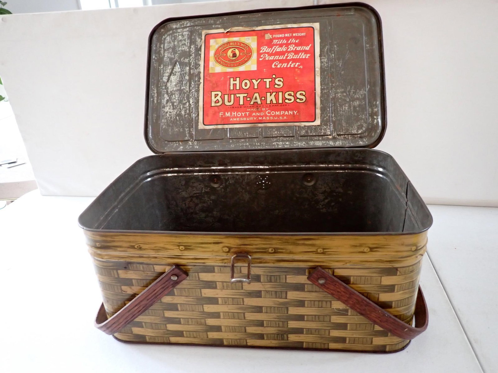 Hoyt's But-a-Kiss Peanut Butter Picnic Basket Tin: Has applied paper label to basket design tin with wooden handles. 176" x 10" x 7" high. Has some wear and denting.