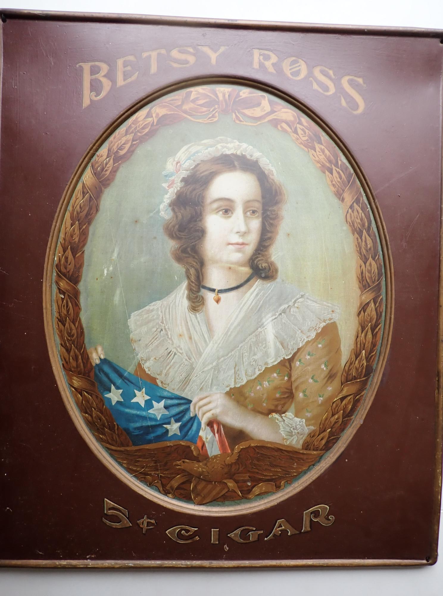 Betsy Ross 5 cent Cigars Advertising Tin Sign: Metal sign with painted image of Betsy Ross with Flag and Eagle. 24" x 20." Indented oval where Betsy Ross's image is. Some wear with denting )mainly on edges and scratch on left side running by her