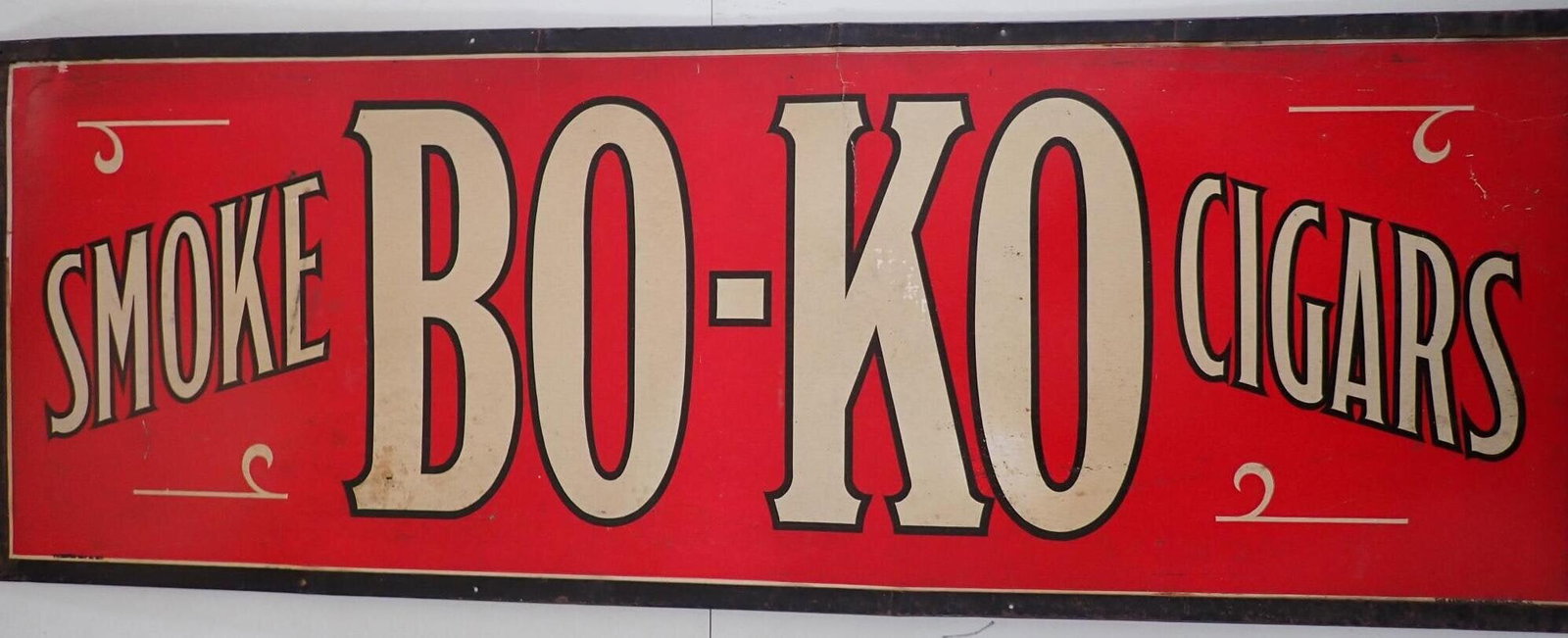 Smoke Bo-Ko Cigars Advertising Sign: Cardboard sign in tin frame. "Patented May 14, 1918." "The Kemper-Thomas Co., Cin., O.". Has some cracking at crease in "K." Other wear. Approximately 15" x 42."