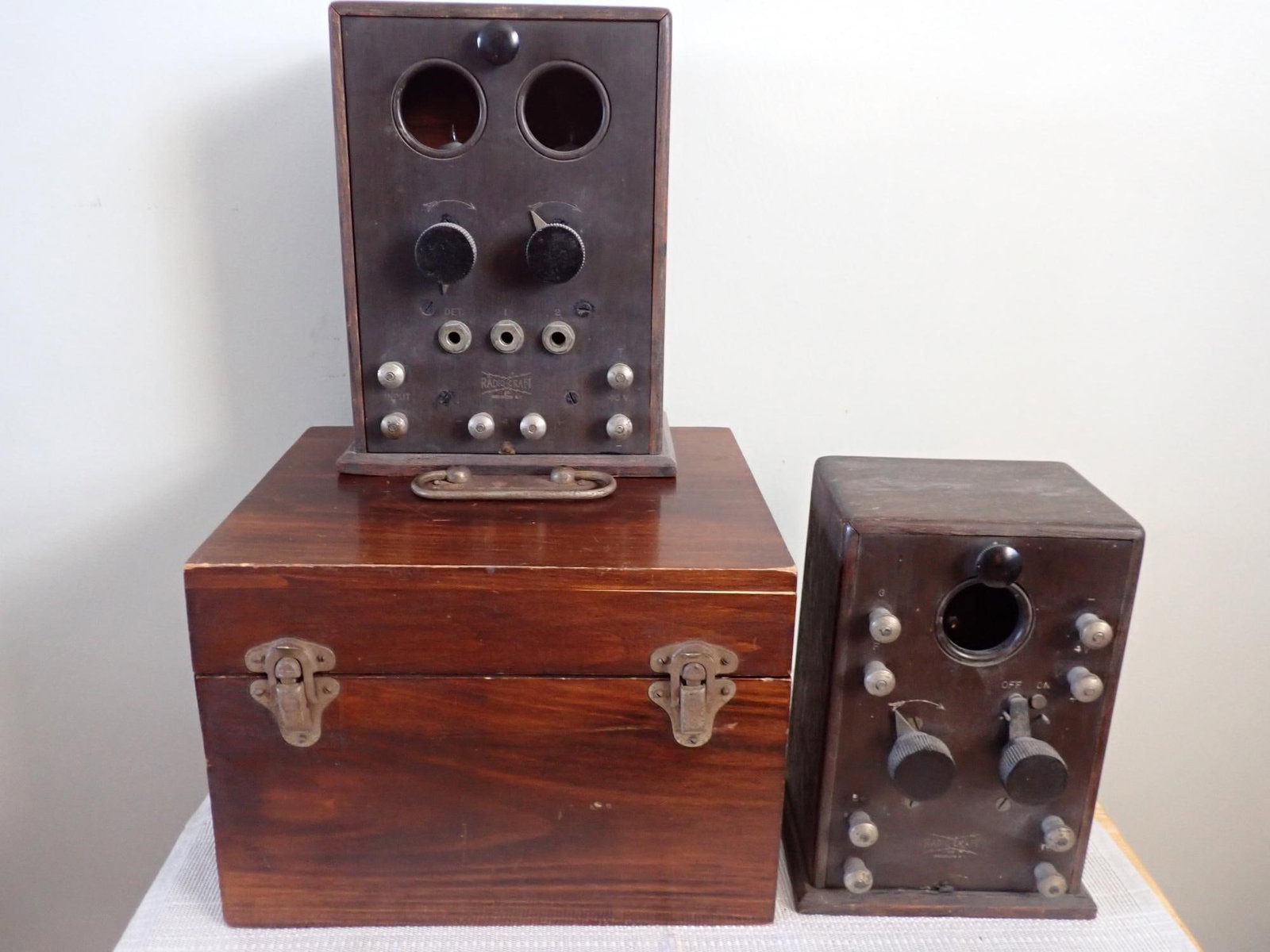 Radio Craft Portable D-4 Radiophone and 2 Receivers: Manufactured by De Forest Radio and Telephone and Telegraph company; wooden case lid askew but attached at the corner. Both Radio RadioCraft receivers have vacuum tubes. Smaller is 7 1/2"h x 5" x 3 1/
