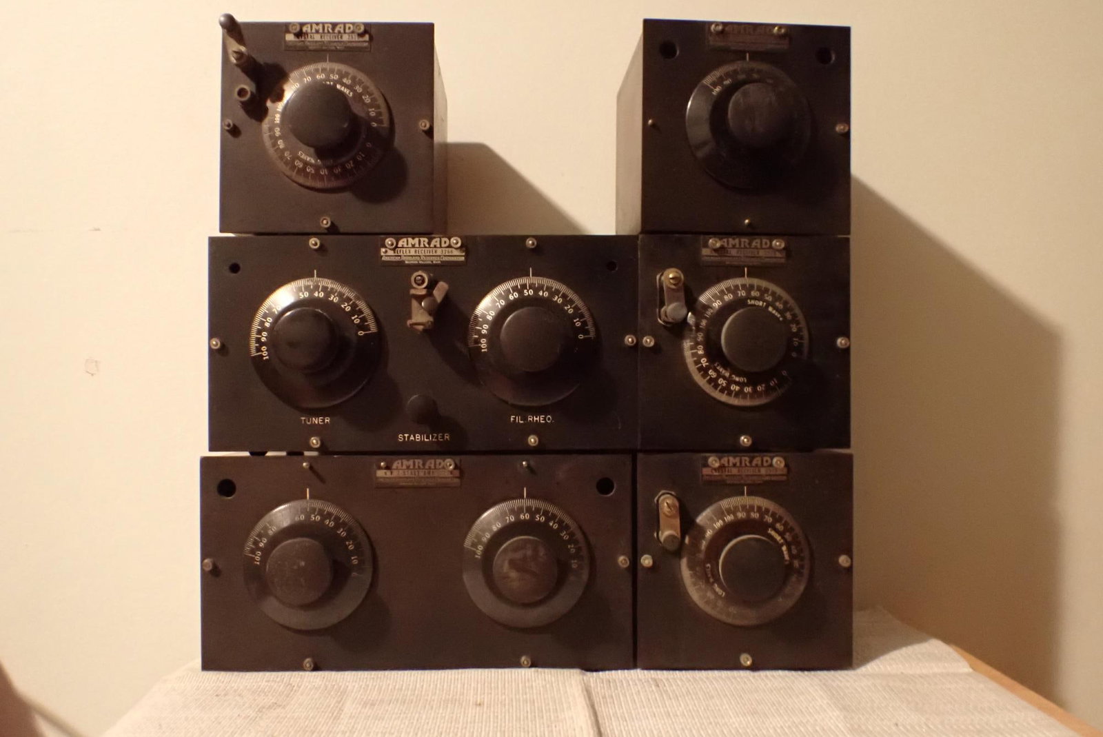 AMRAD Radio Equipment 7 Pieces: Reflex receiver 3366 and V.T. 2 stage amp 2776 with tubes 10" x 5", three crystal receivers 2575, and one V.T. stage amp 2766. AMRAD adjustable Load Coil 2962 in box with loose flaps. All pieces