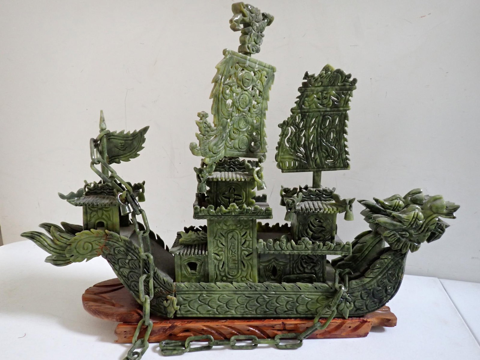 Chinese Carved Jade Ship on Stand: Carved with dragon head reticulated sails and cabins on wood base. Approximately 17 1/2" inches high including wood base. 23" wide. Most complete with just a couple of small pieces missing.