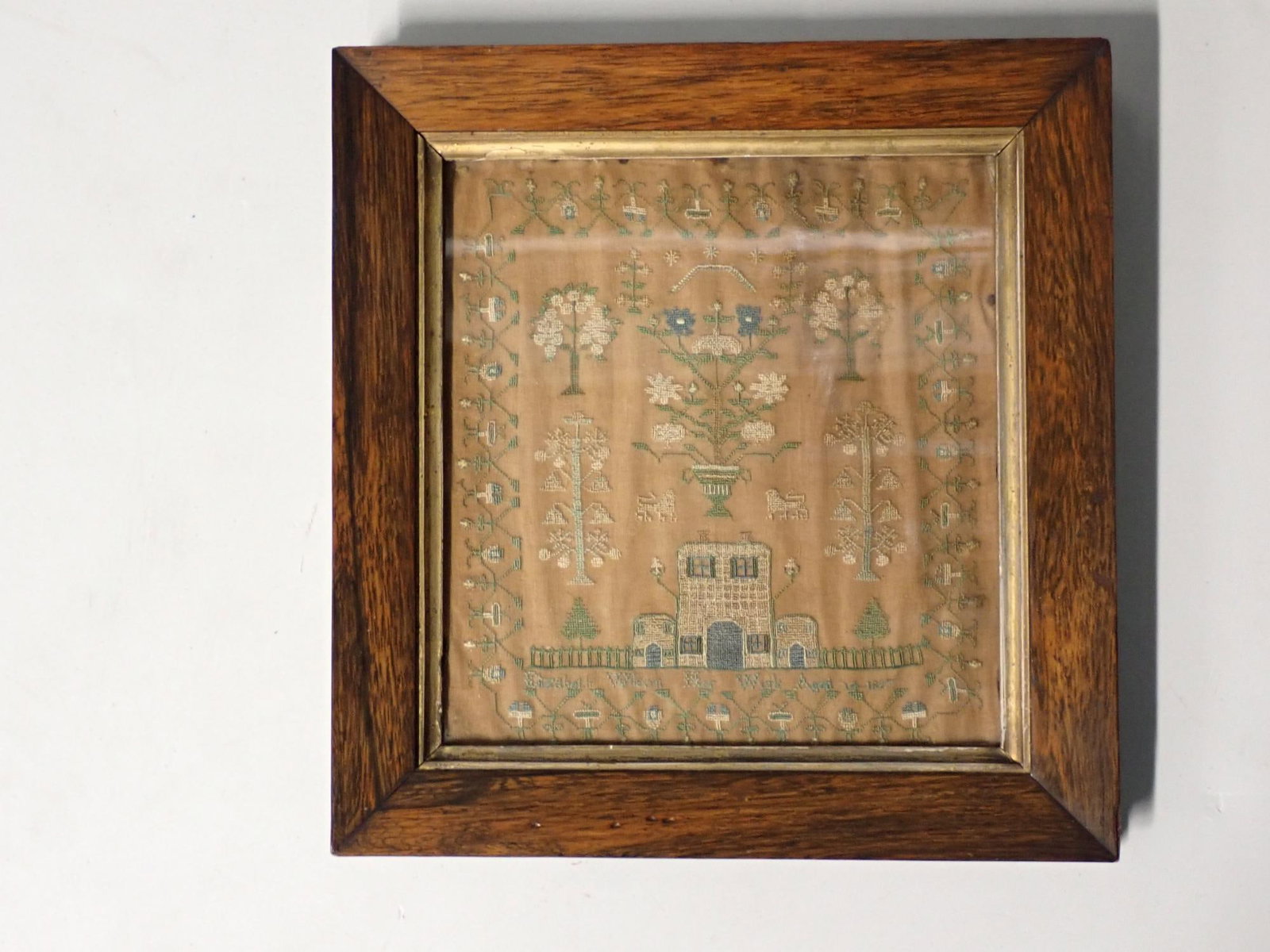 1827 Elizabeth Wilson sampler: Sampler with floral and buildings displayed title on bottom Elizabeth Wilson Her Work Age 14 1827 Frame 11" x10 1/2" sampler 8" x 7 3/4" fabric staining .