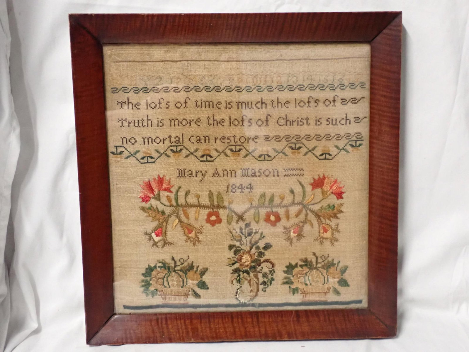 1844 Mary Ann Mason Sampler: May Ann Mason 1844, motif alphabet, numbers and religious verse. Crewel and cross stitch flower design . Some fading and discoloration. Frame 15" x 14 1/2" Sampler 12 1/2" x 12"