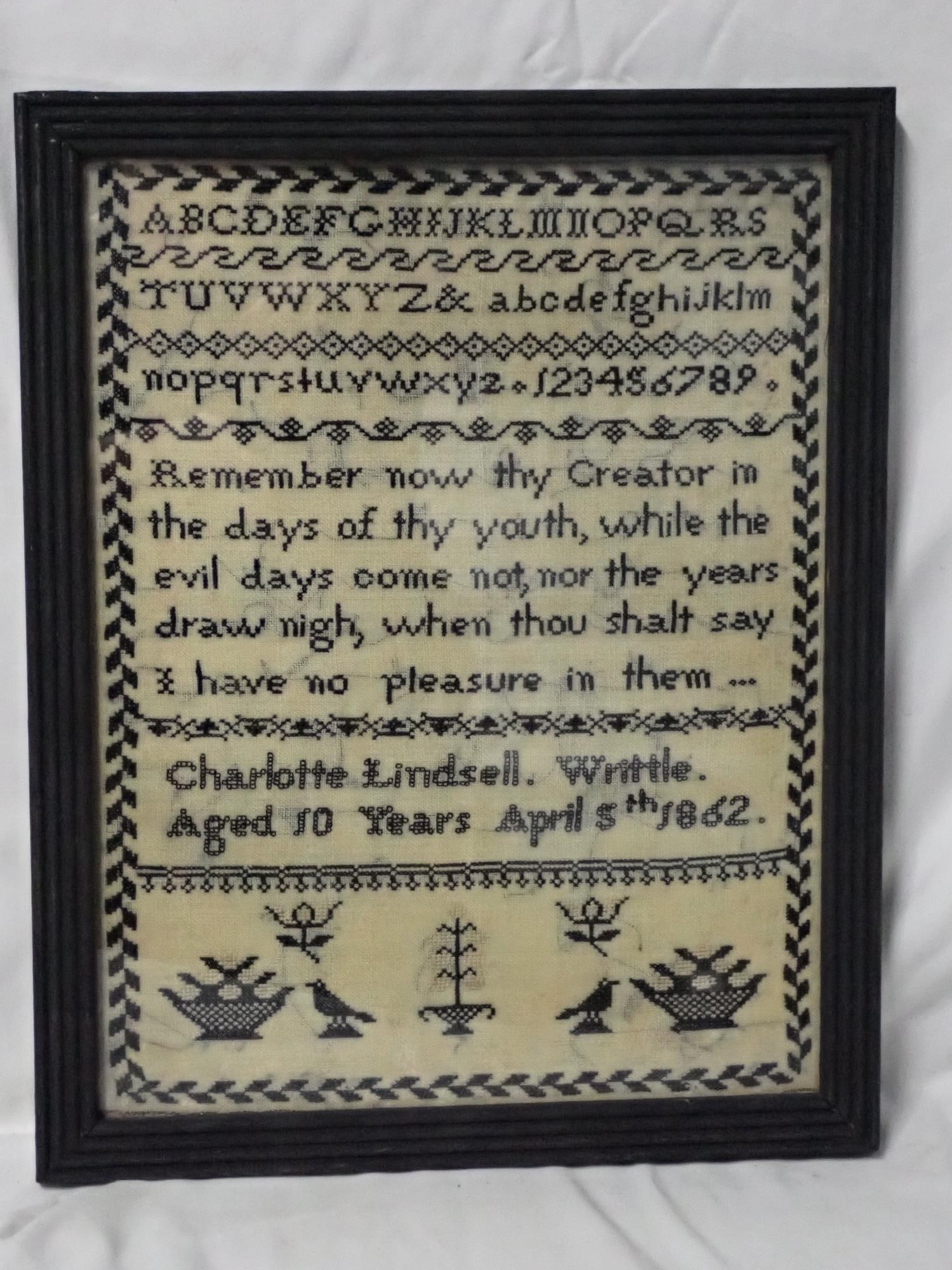 1862 Charlotte Lindsell Sampler: Charlotte Lindsell Writtle Aged 10 Years April 5th 1862. Black and white sampler with alphabet and numbers A religious verse in the middle. Geometrical border. Bottom motif is birds, flowers and