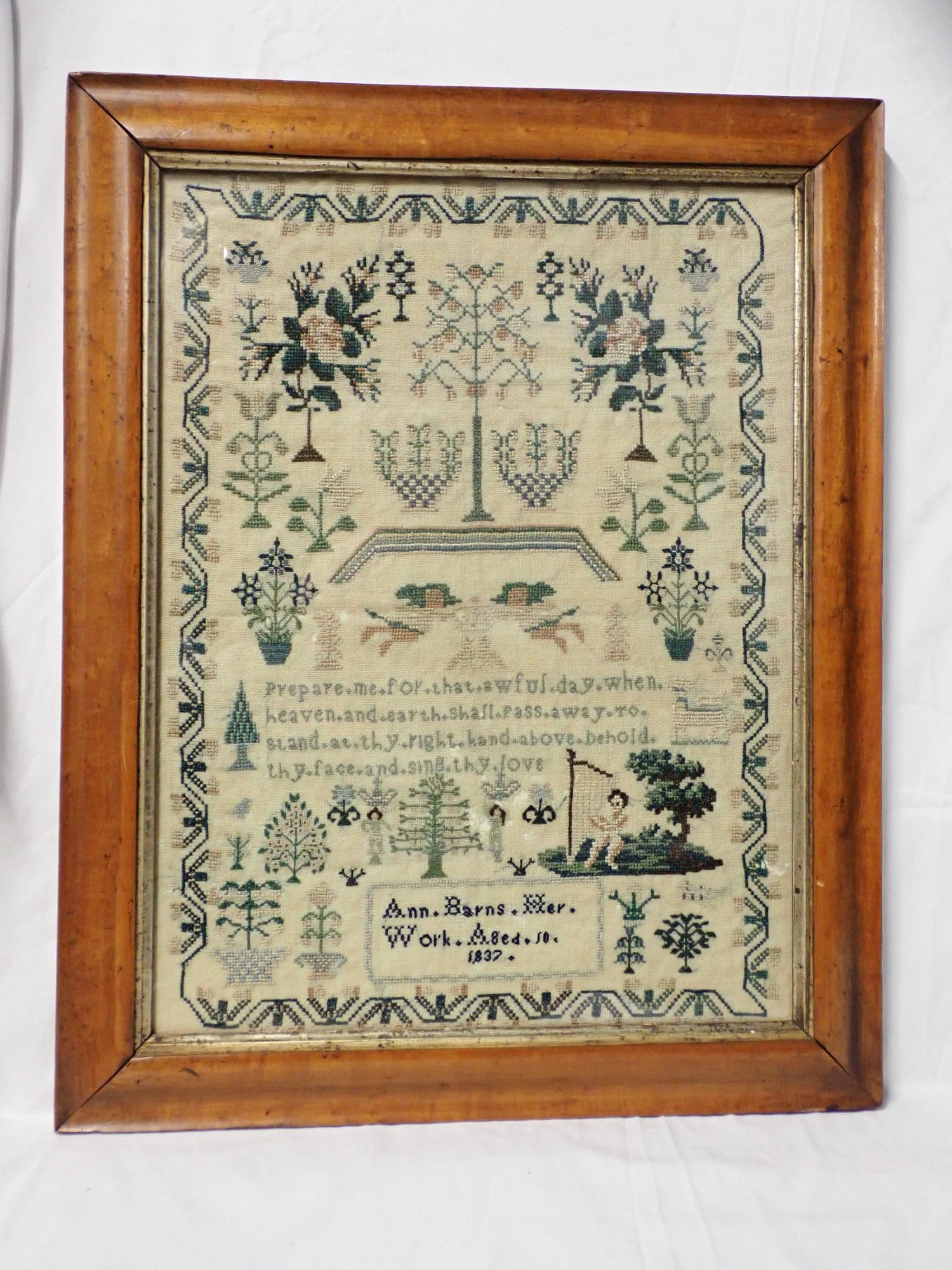 1837 Ann Barns Sampler: Ann Barns Her Work Aged 10? Motif Floral, animals, Cherubs one playing a harp. Religious verse in center. Vine and flower border. Fabric loss, fabric discoloration Frame 19 1/2" x 15 1/2" Sample 16"