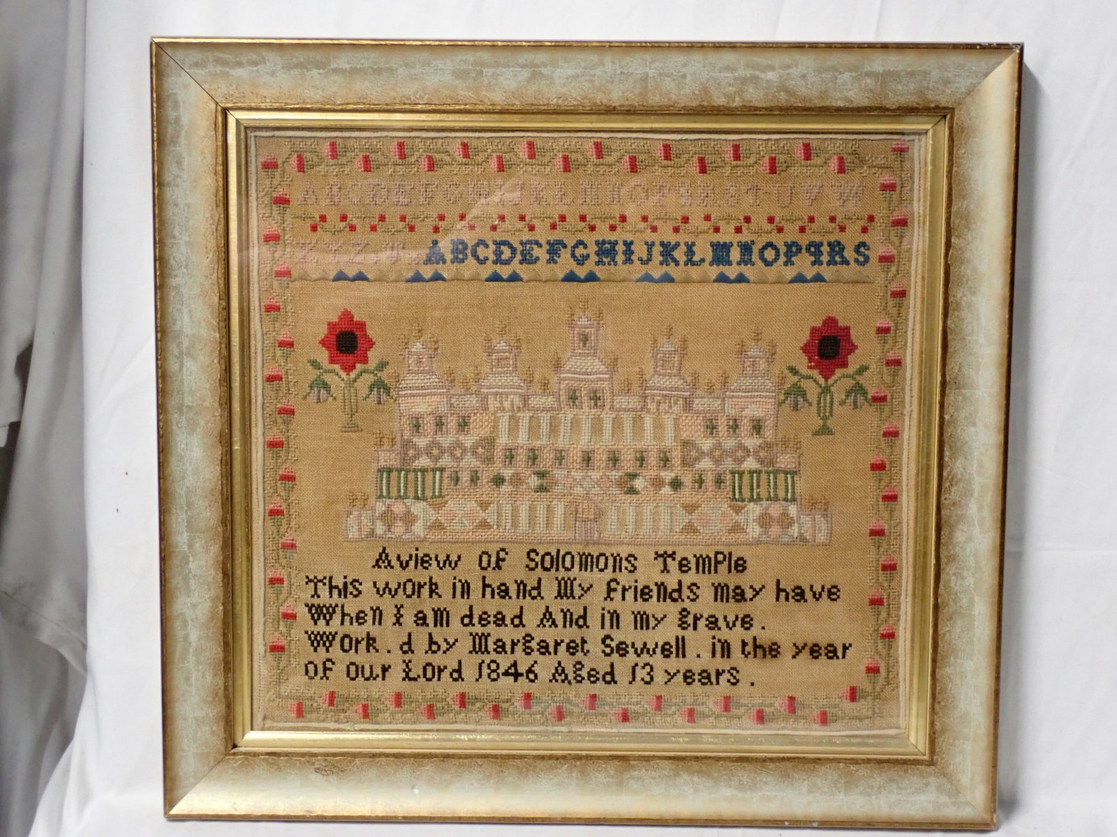 1846 Margaret Sewell Sampler: Work.d by Margaret Sewell. in the year of our Lord 1846 Aged 13 years. Alphabet A View of Solomon's Temple Short verse at bottom. Motif Solomon's temple, bright red flowers and fine and floral border.