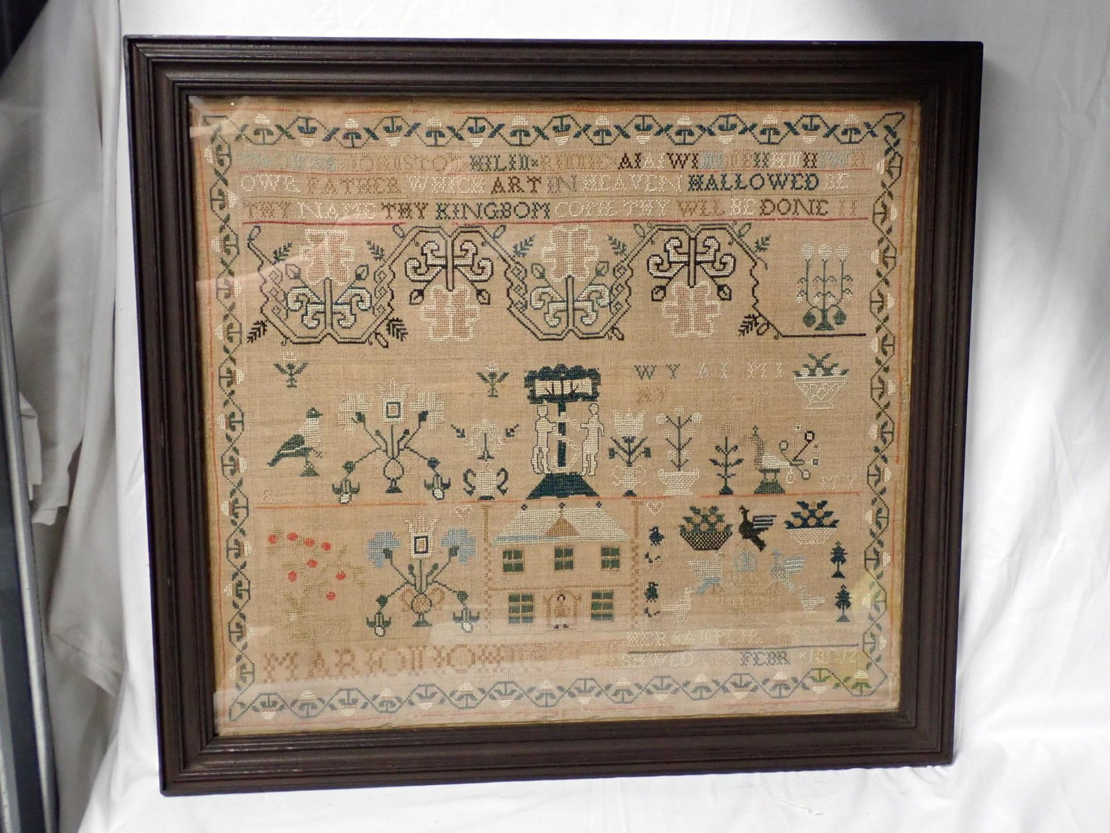 1812 Marion Johnston Sampler: Marion Johnson Her Sampler Aged 19 Sewed this Febr 18012 (mostly likely 1812). Religious verse at top. Motif geometric designs, Adam and Eve, house birds peacocks vince and floral border. Frame 20