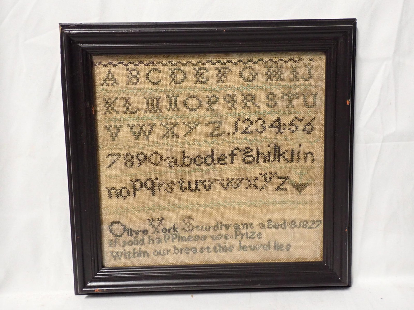 1827 Olive York Sturdivant Sampler: Olive York Sturdivant aged 8 1827 Alphabet and numbers, Verse at bottom Slight fabric discoloration Frame 9 3/4" x 10 1/4" Sampler 7 1/2" x 7 3/4".
